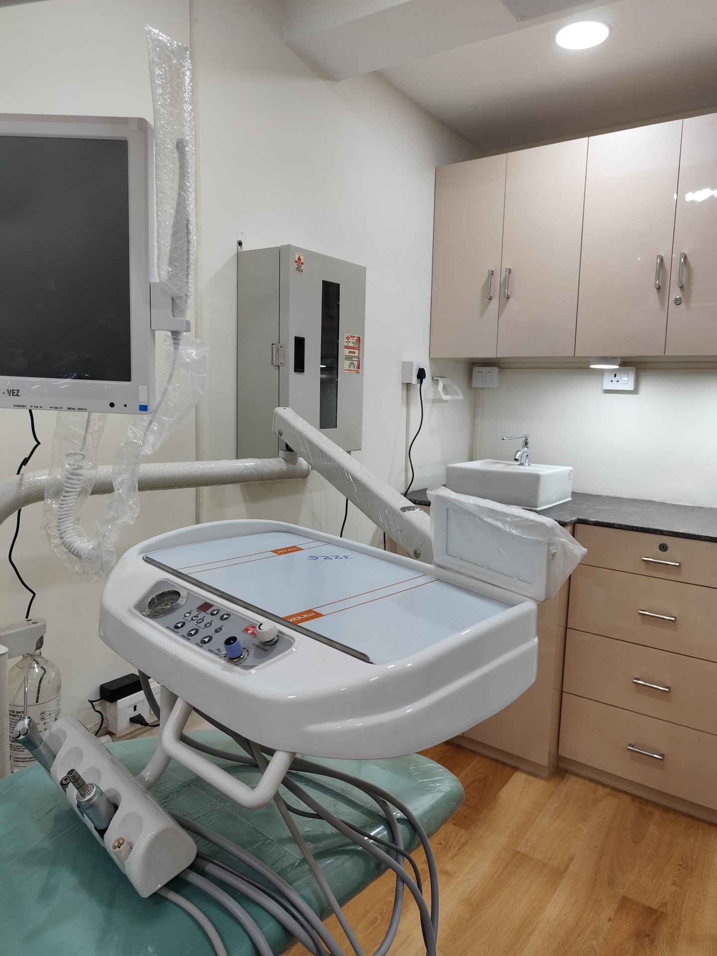 Modern dental clinic setup featuring an advanced delivery unit, monitor, and clean surgical workspace.