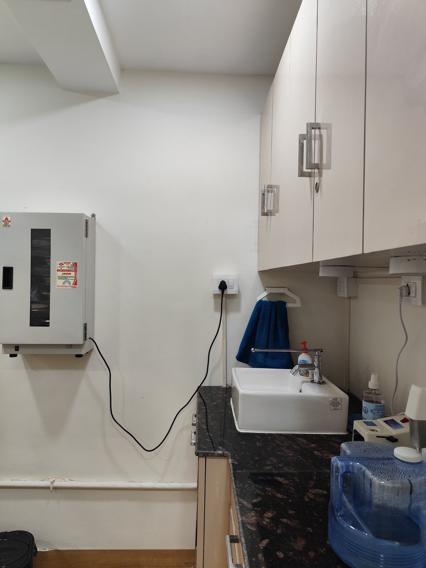 White medical hand washing station with a small sink, chrome faucet, and uv chamber 