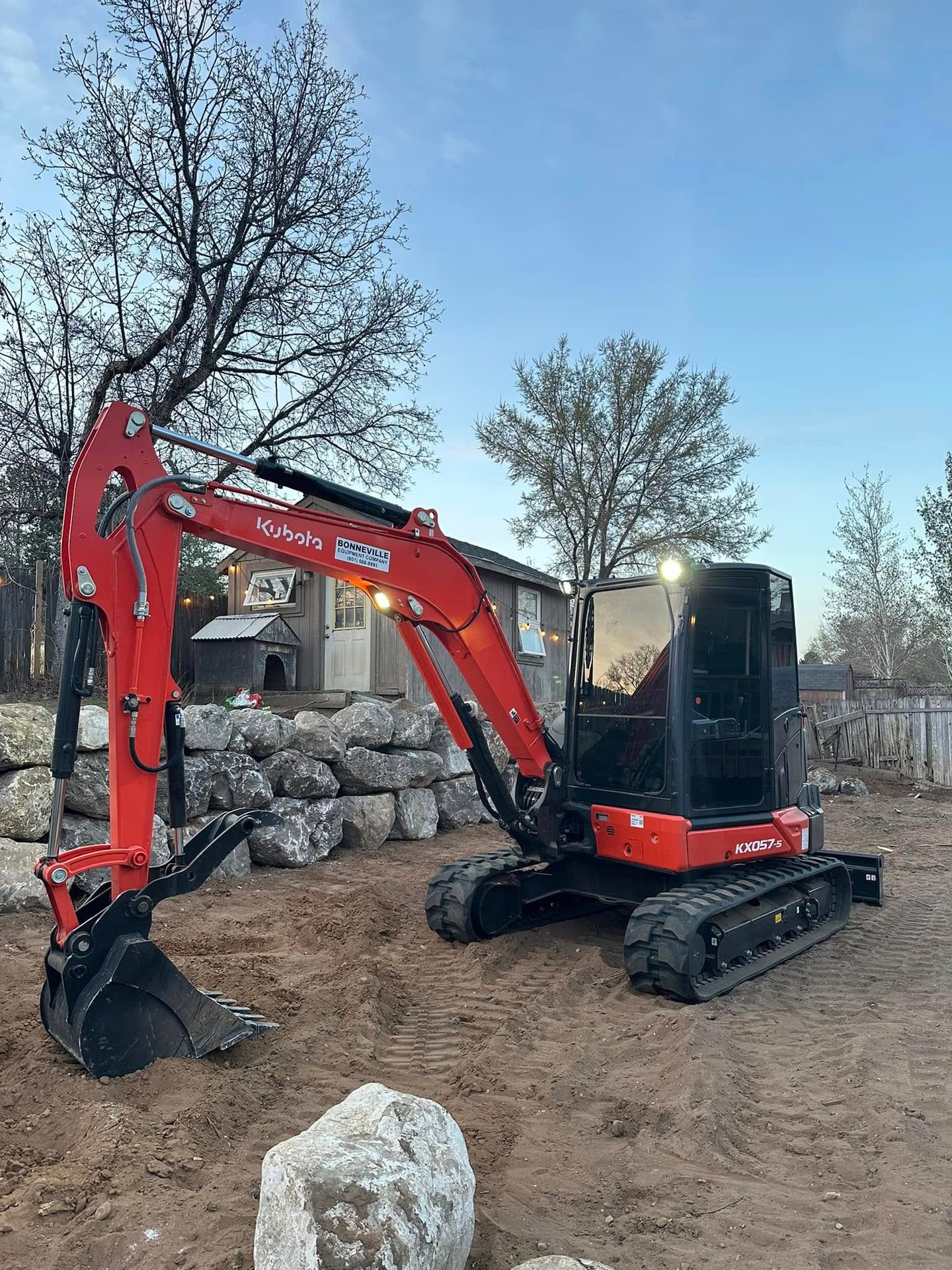 Kubota sitting idle next to completed boulder wall in Ogden, UT