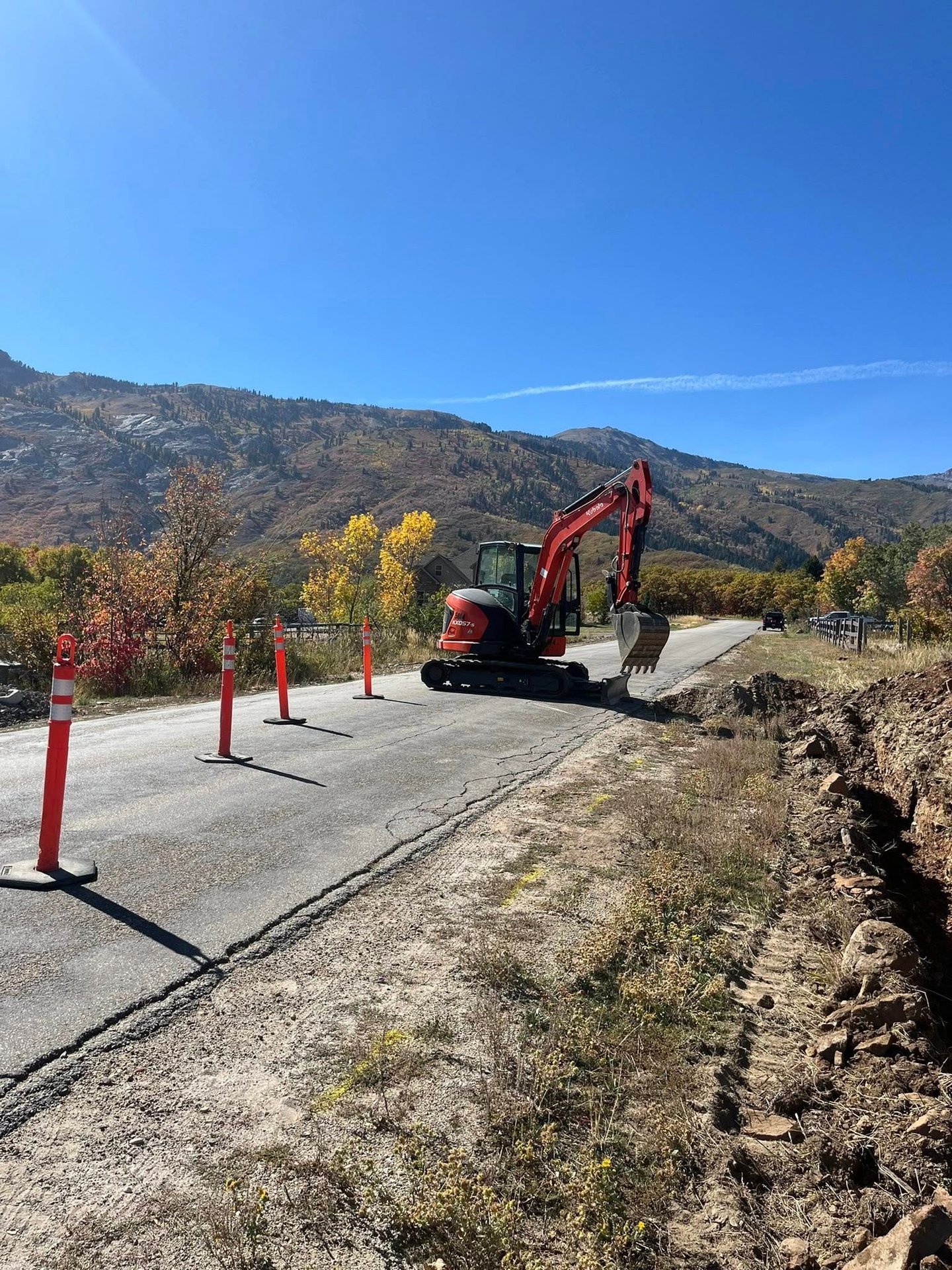 Kubota excavator sitting idle with Utah mountains in background