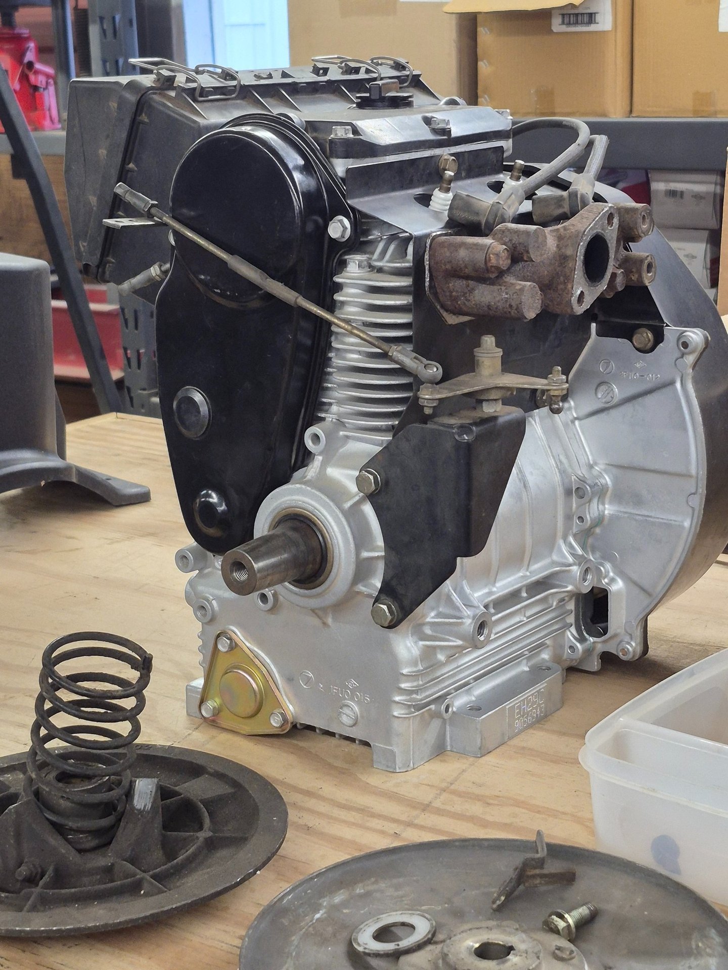 newly rebuilt engine sitting on a wooden bench in a small engine shop