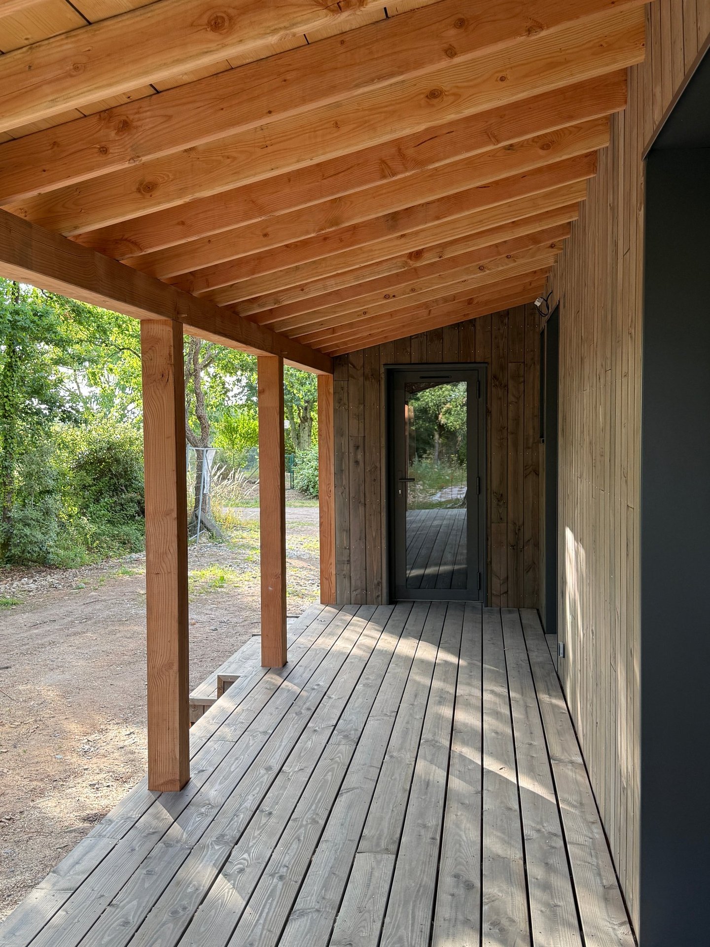 Auvent et terrasse en lames de douglas naturel pré grisé maison ossature bois Baden Morbihan