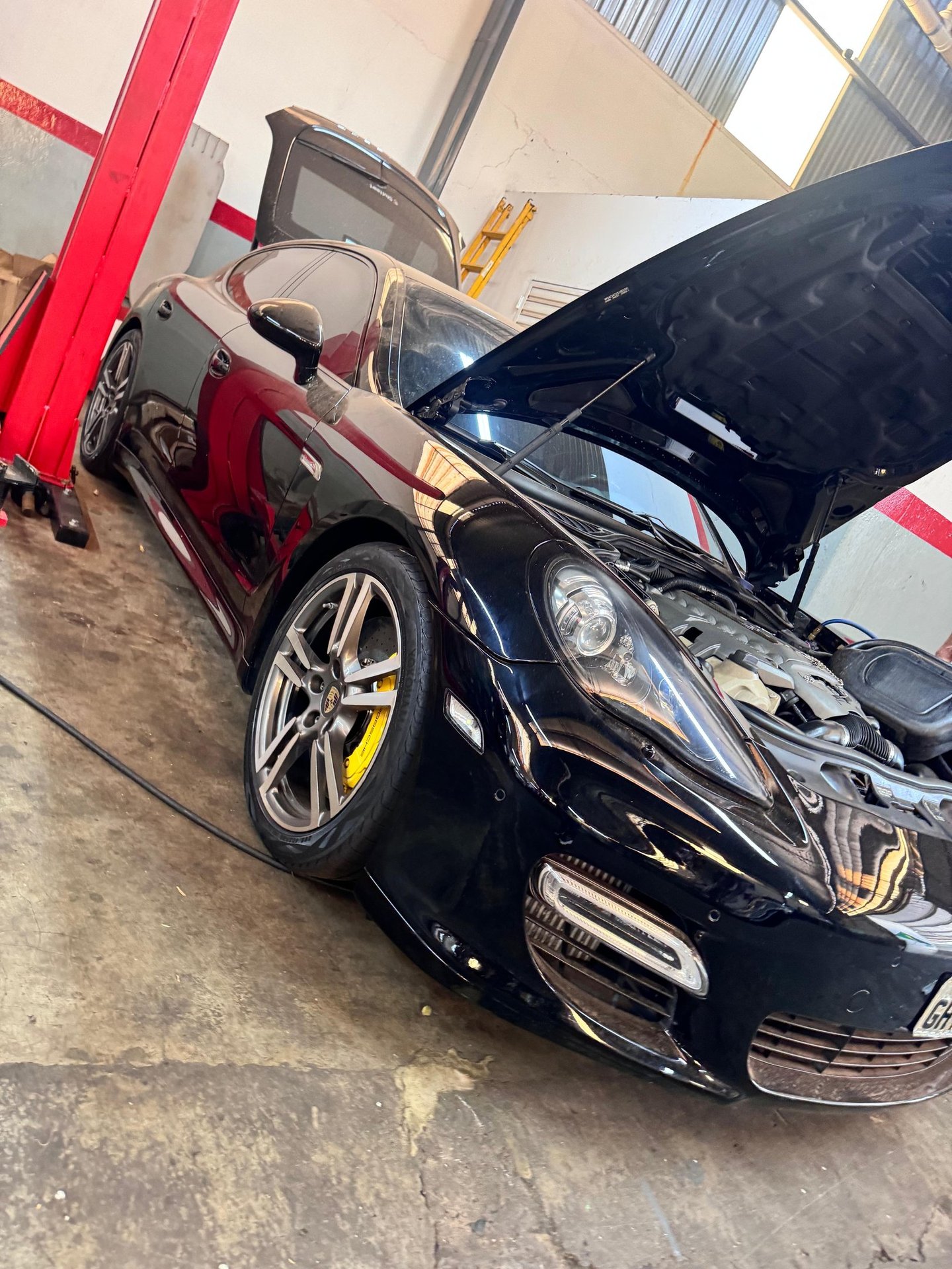 Um carro com o capô aberto, pronto receber a troca da sua bateria em uma loja de baterias de carro.