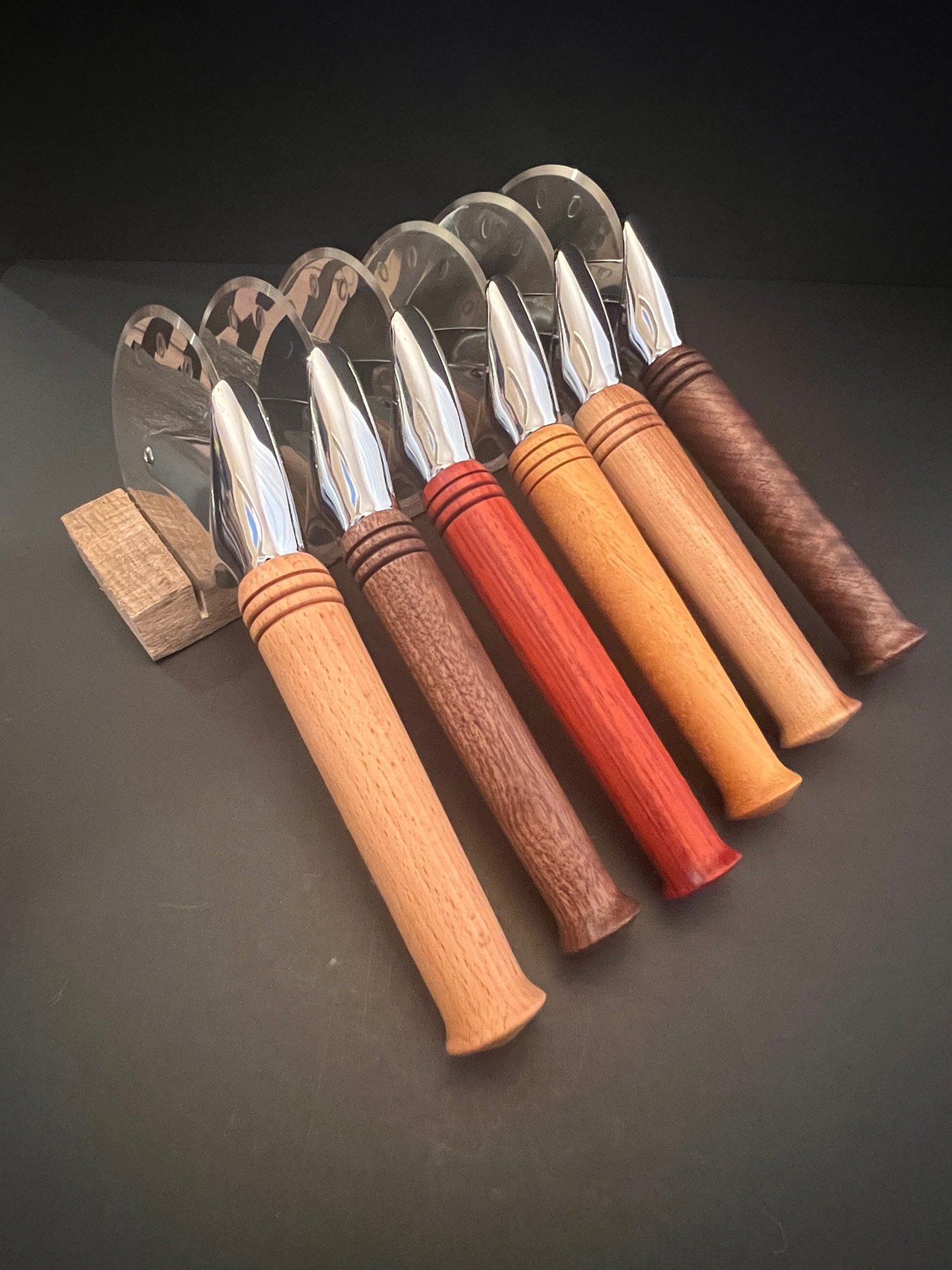 Collection of pizza cutters with various wood handles