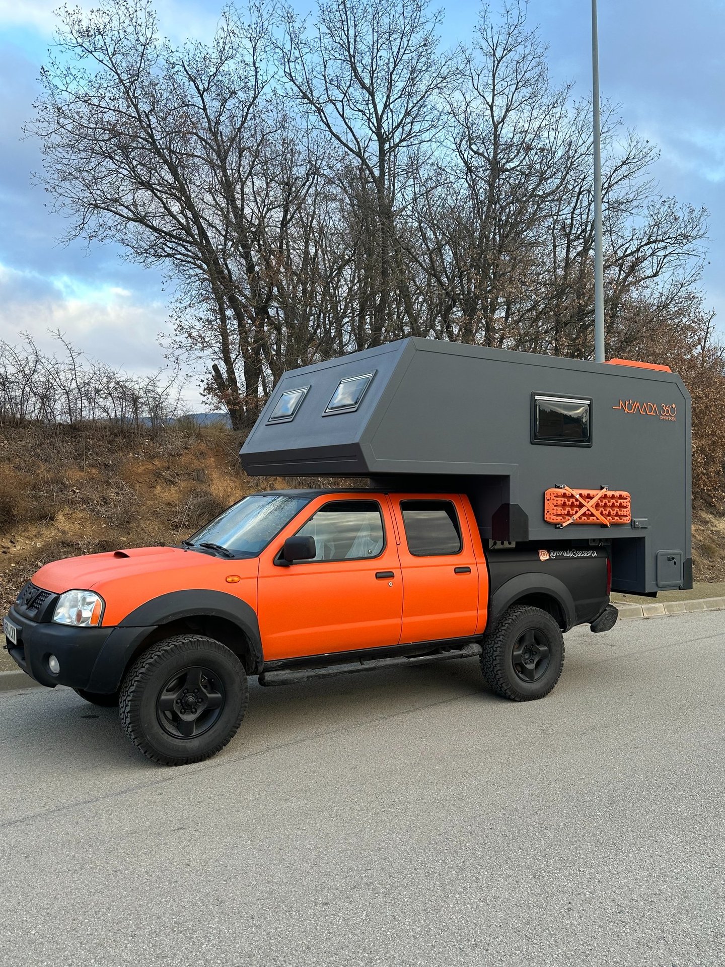 vehículo pick up de color naranja con cabina vivienda