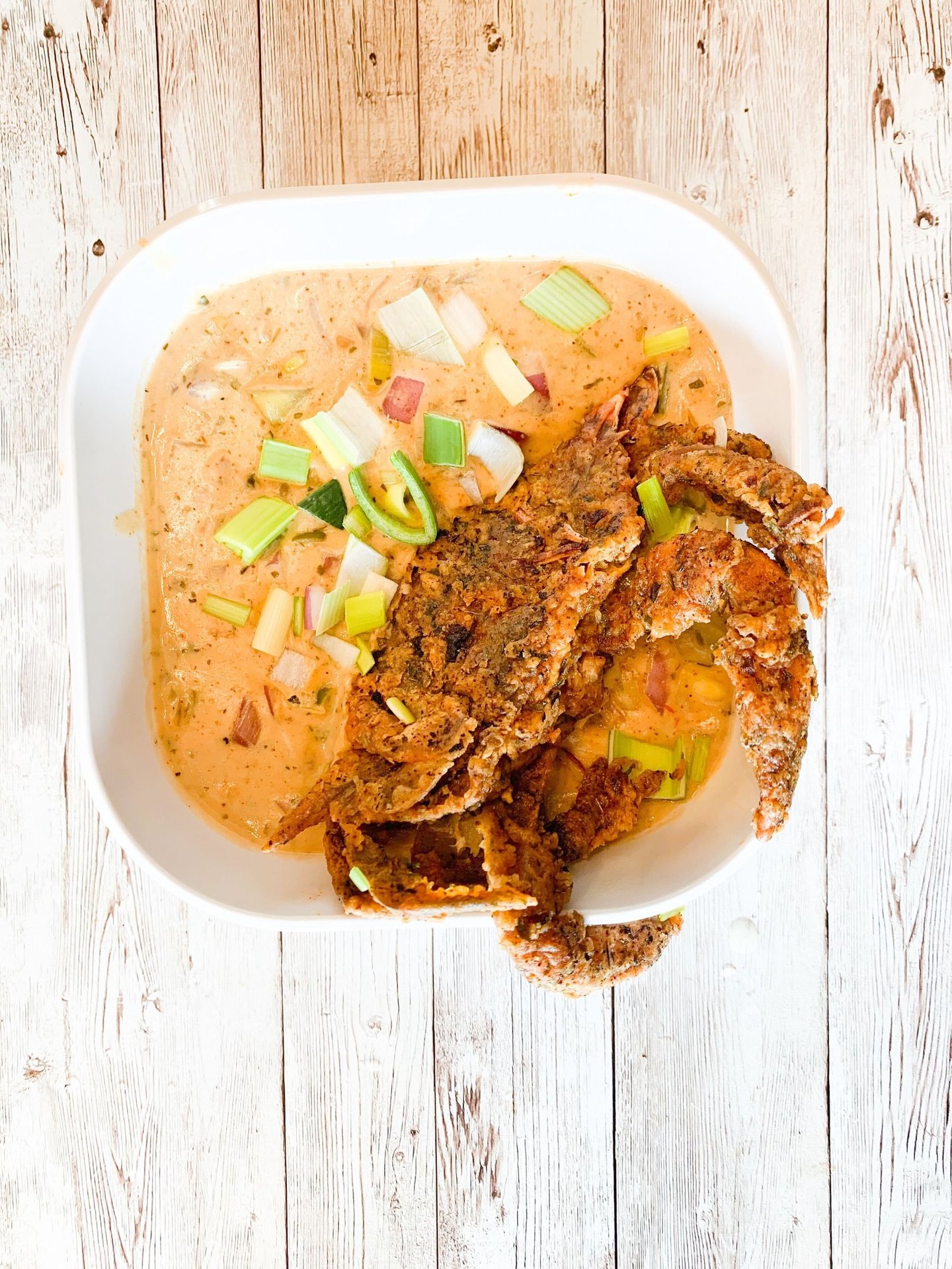 a bowl of soup with a fried crab