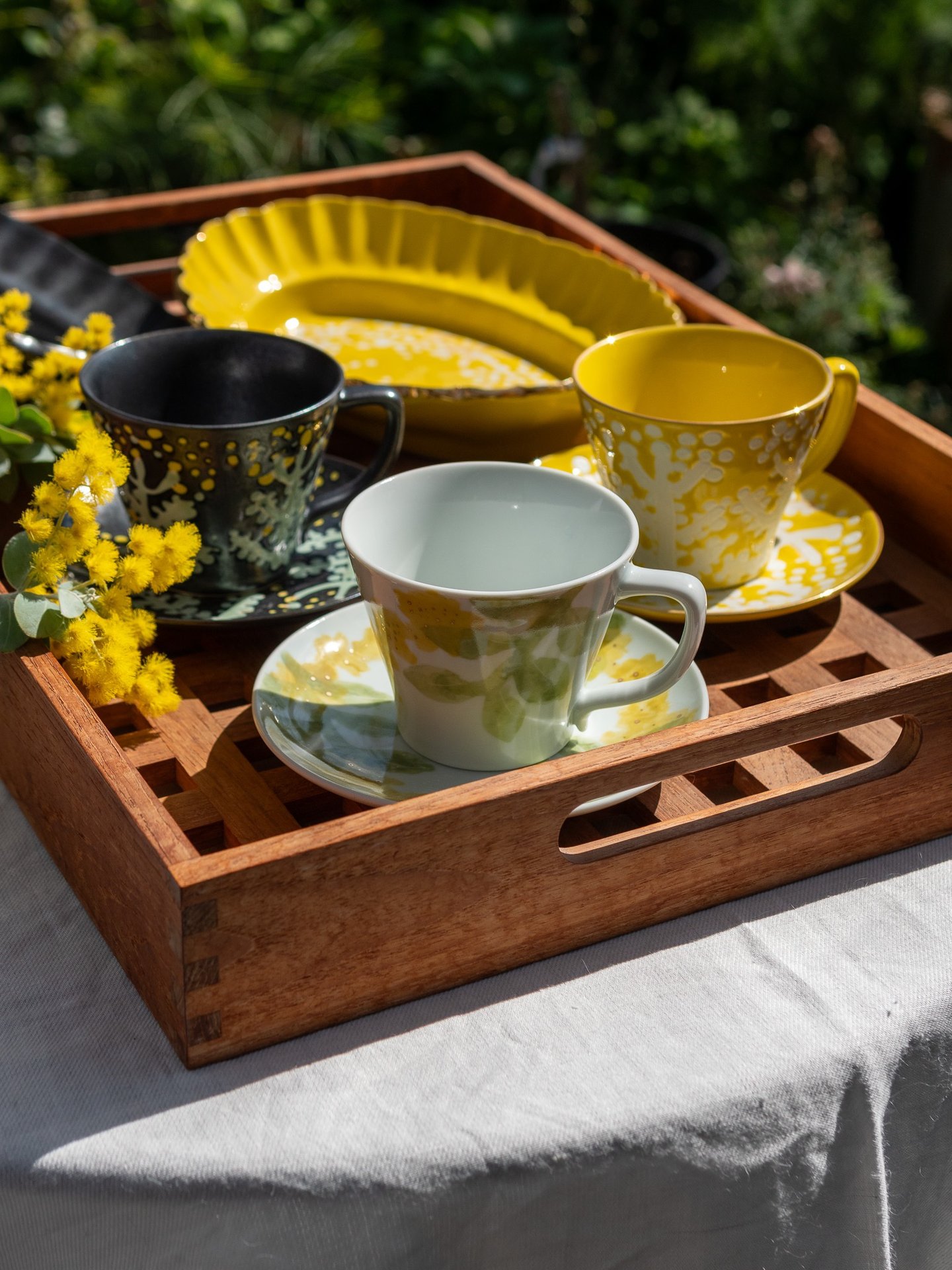 a tray with a tray of tea cups and a tray with a cup of coffee
