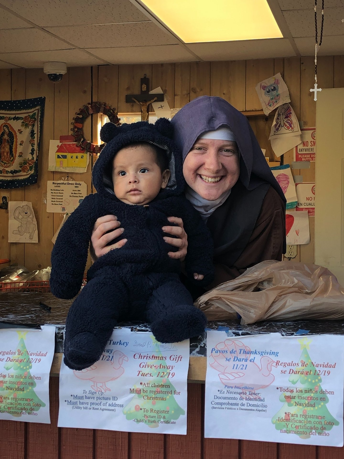 A Franciscan Daughter of Mary and a very cute baby pose for a picture at the Rose garden Mission