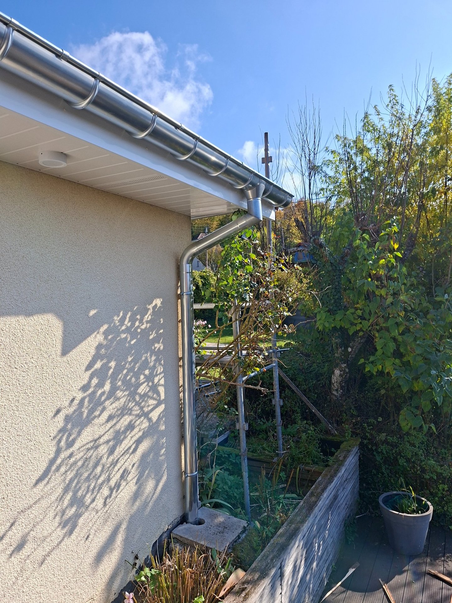 Habillage des débords de toiture en pvc blanc réalisés à Vandoncourt avec chéneaux en zinc.