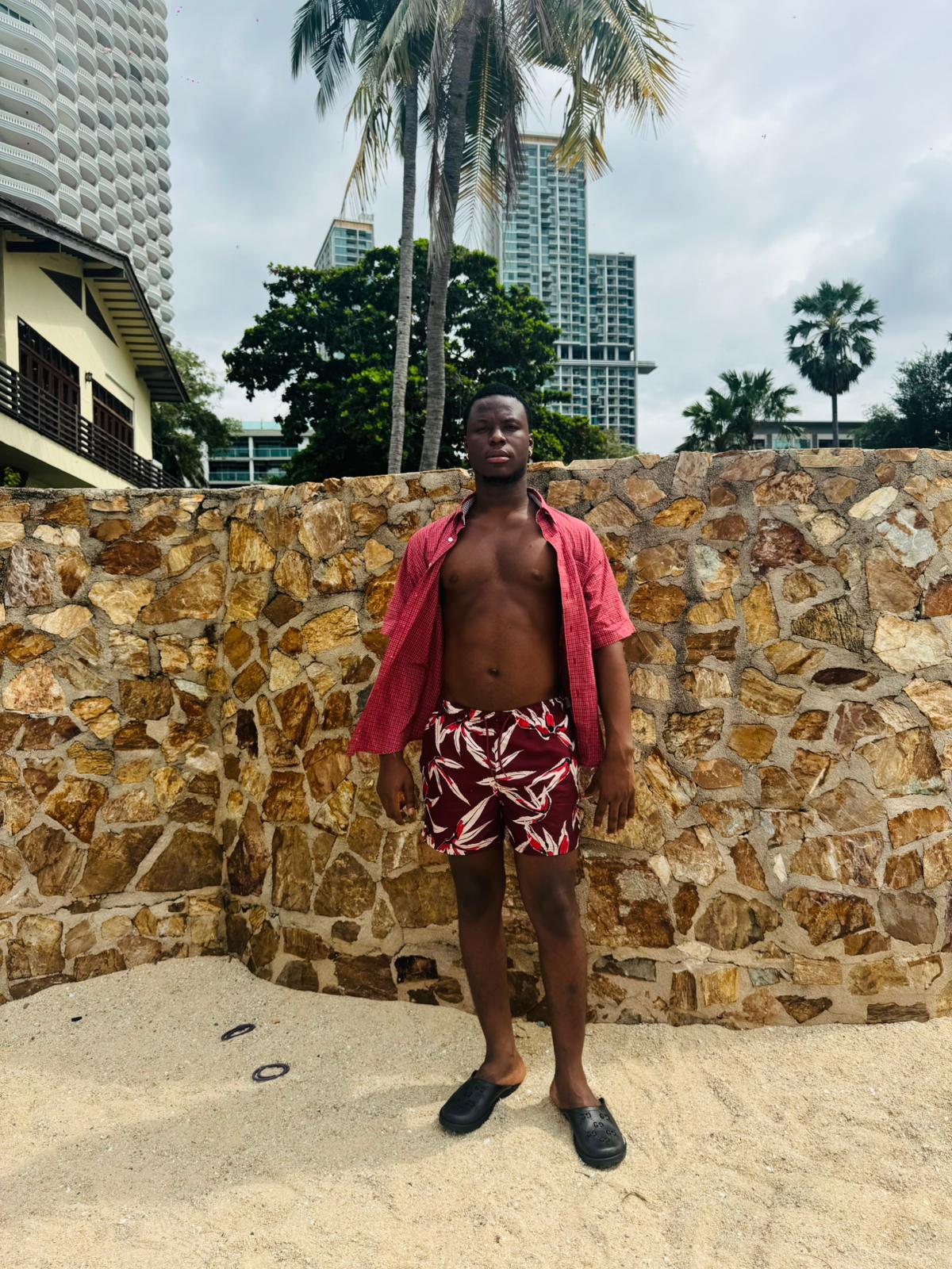 Male therapist wearing red and white shorts and red short sleeve shirt with buttons open
