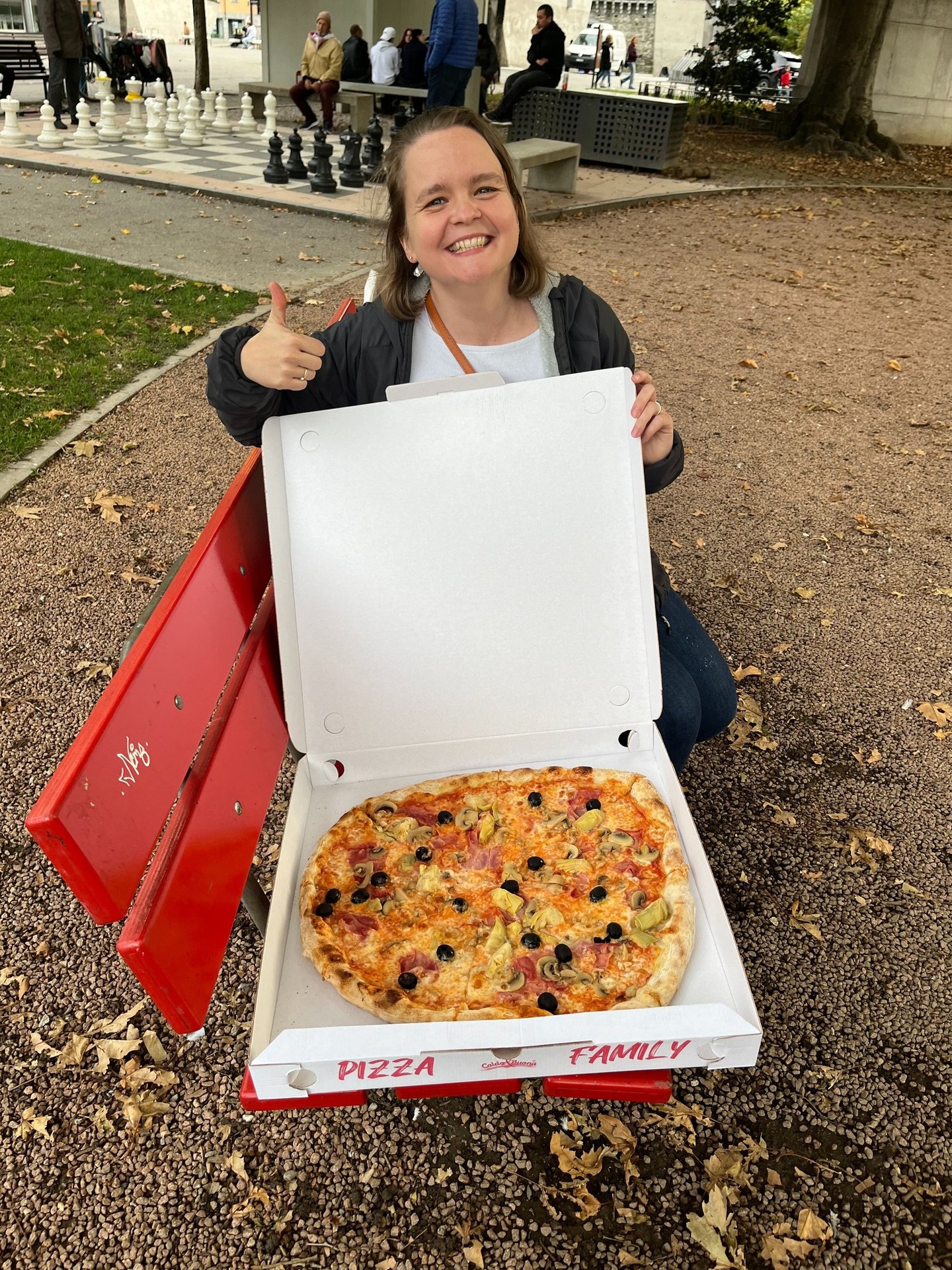 Corinne from Hidden Switzerland Travel with a massive pizza in Bellinzona