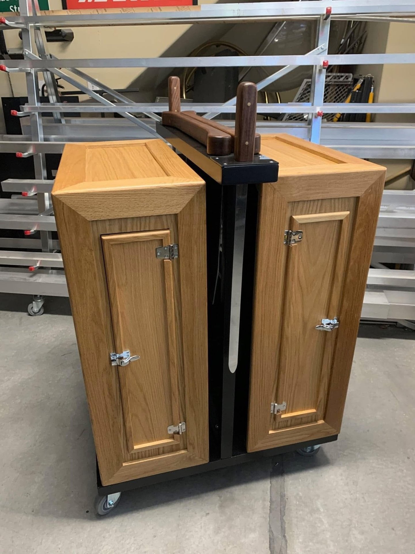 Professional magic stage prop for a sword cabinet illusion made of oak wood on a rolling metal frame.