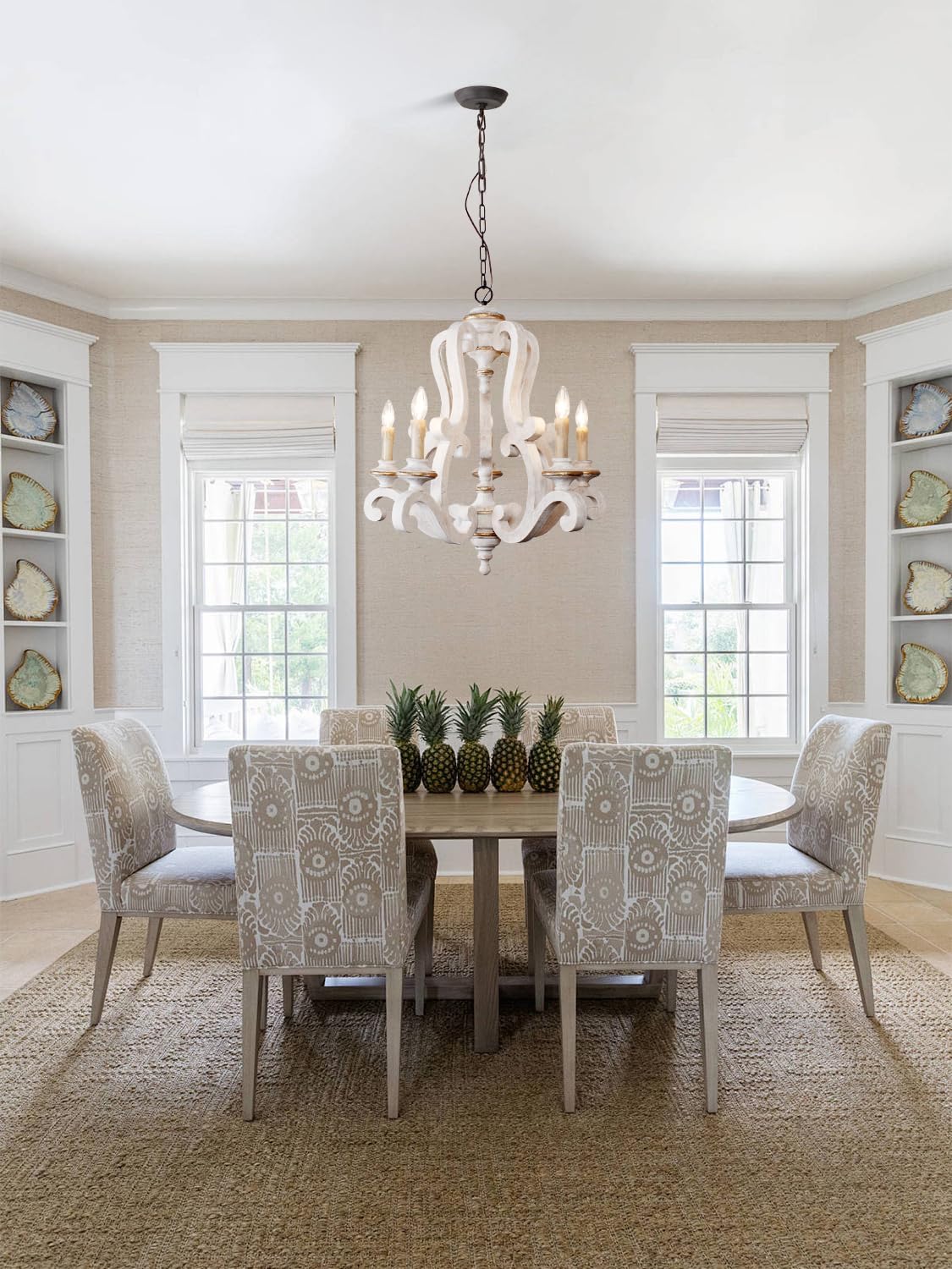 Elegant dining room with a white wooden chandelier and upholstered chairs around a natural wood table.