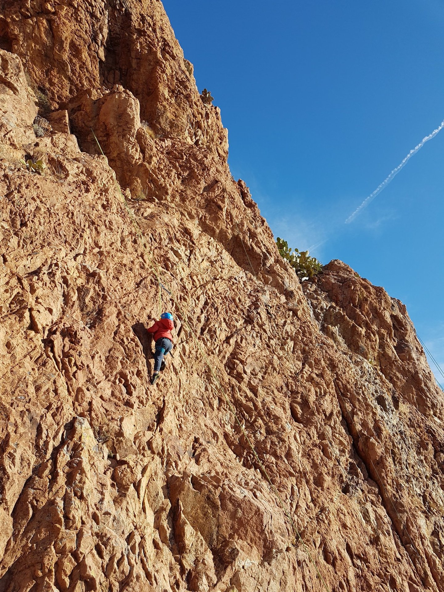 Enfant qui grimpe un mur rougeoyant