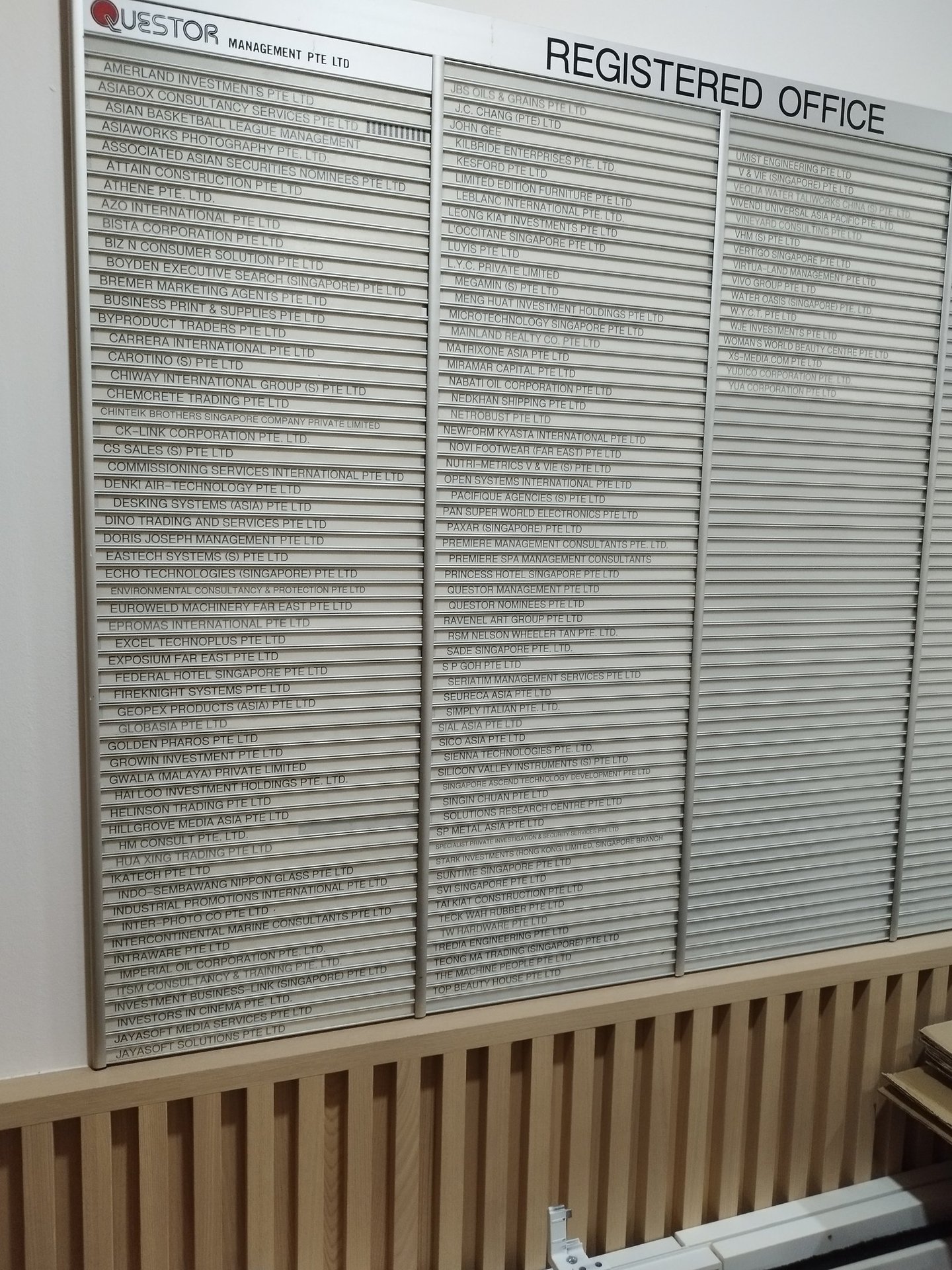 signboard with registered office names care of Questor Management Pte Ltd in Singapore