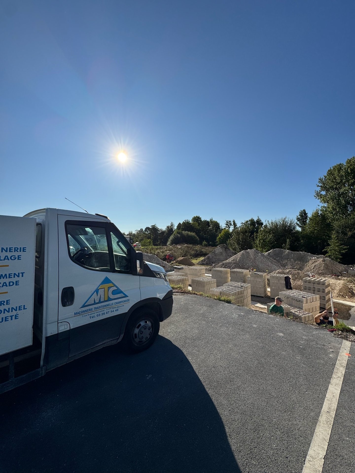Un camion de chantier MTC garé sur un chantier de maçonnerie, avec des palettes de parpaings à Reims