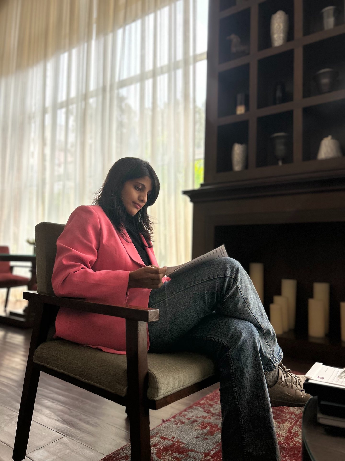 a woman sitting in a chair with a bookcase