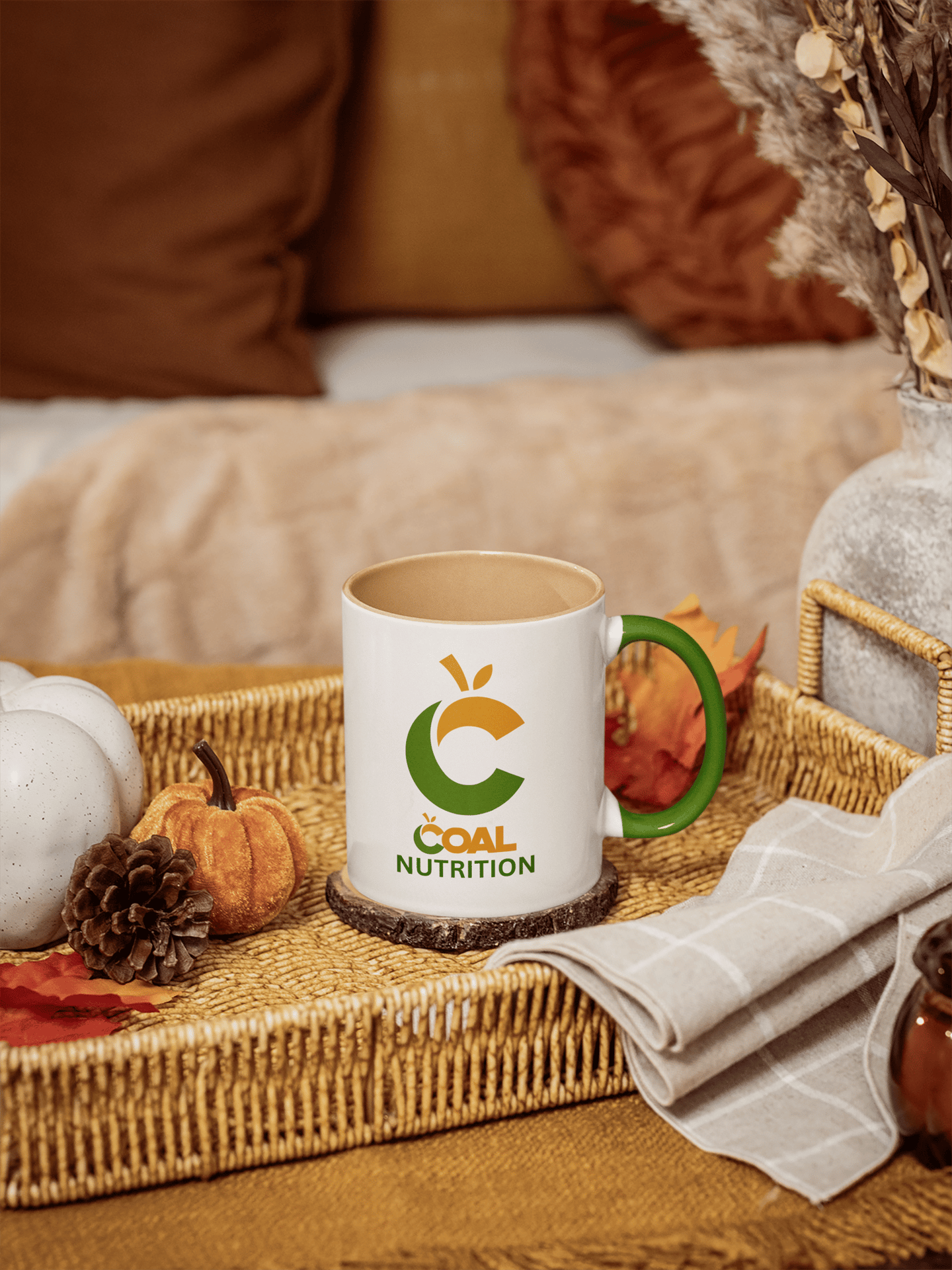 Coal Nutrition branded coffee mug on a wicker tray with autumn pumpkins and pinecones.