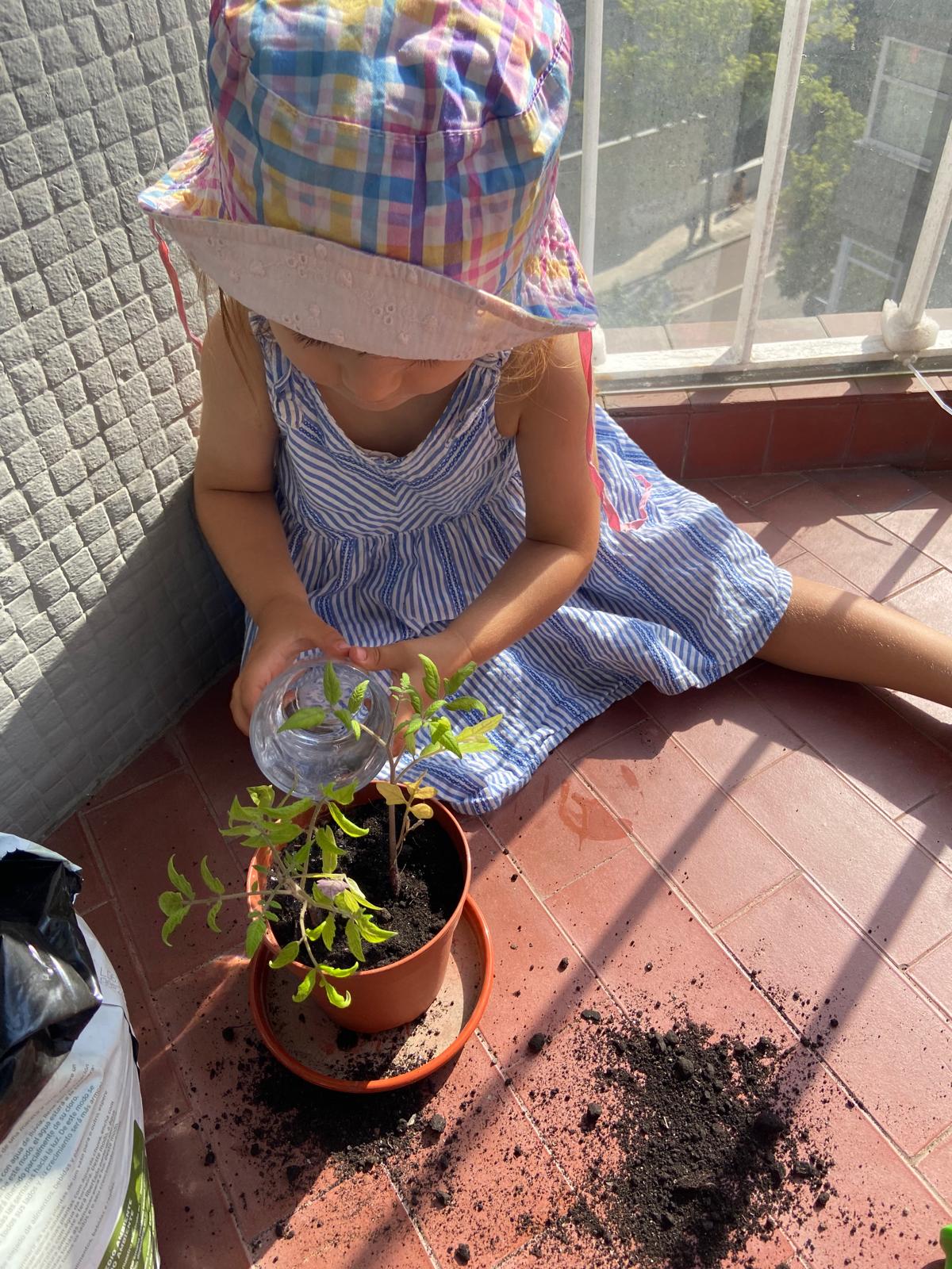 criança e bebé a regar as plantas