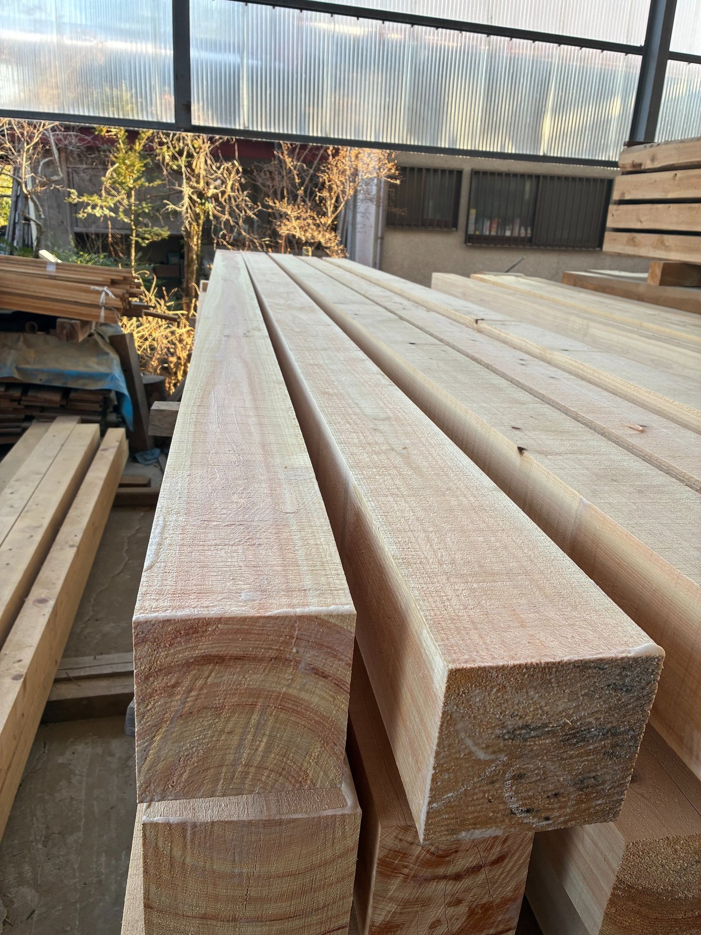 Stacked square hinoki cypress flitches in a lumber yard for construction and carpentry.