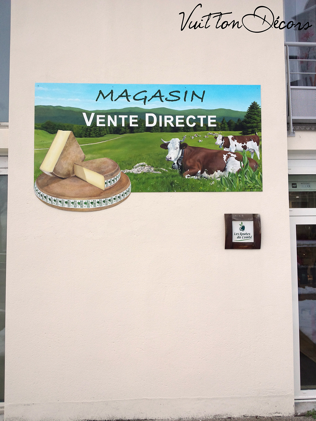 Enseigne peinte du magasin d'une fromagerie à Orgelet (39), Comté, vaches et paysage jurassien.