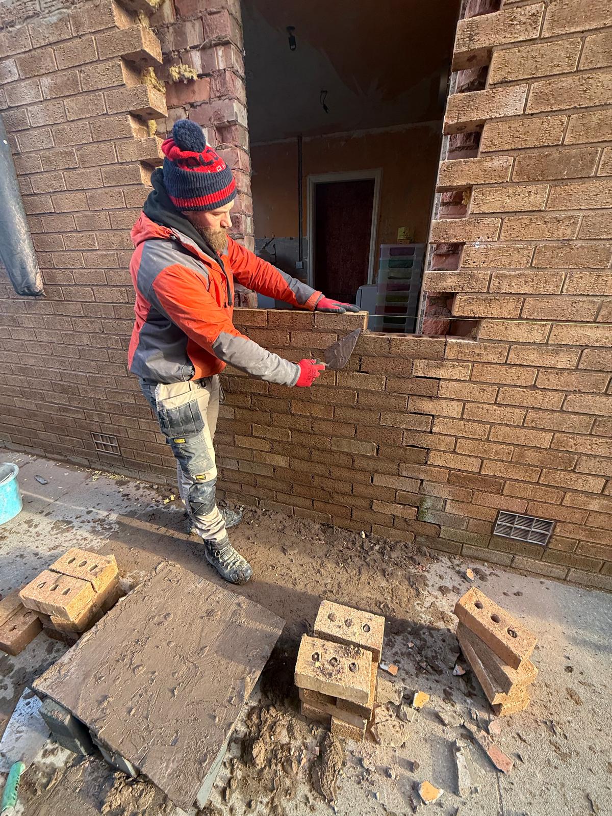 Bricklayer repairing brickwork on residential property in Southport