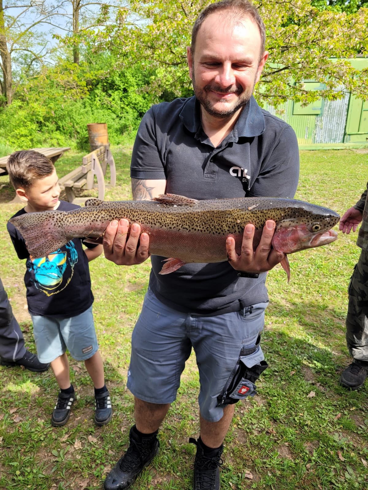 a man holding a fish on a field