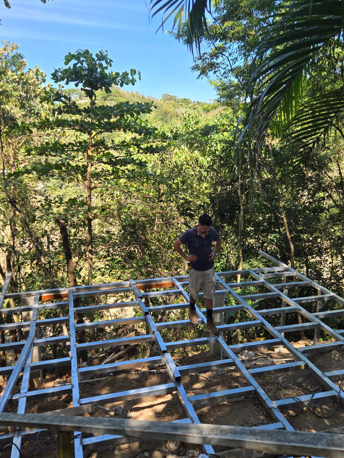 owner of NANCE, Jose Ponce standing on a metal steel structure for base of a house