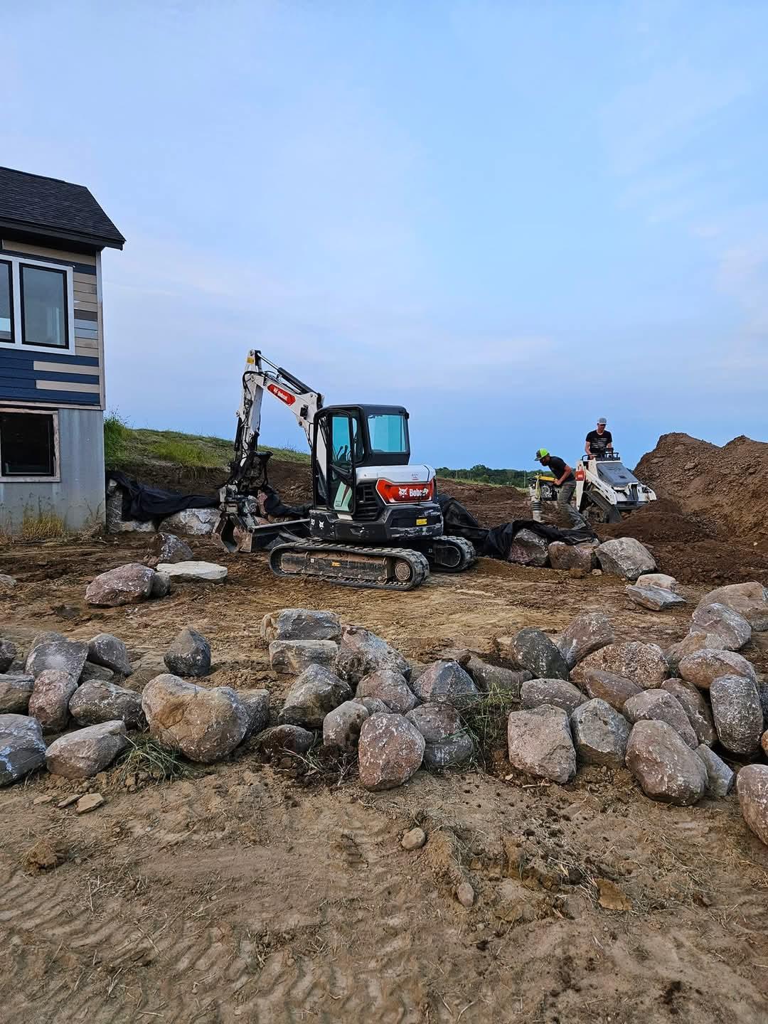 Bobcat Excavator and Bobcat mini excavator building a block retaining wall