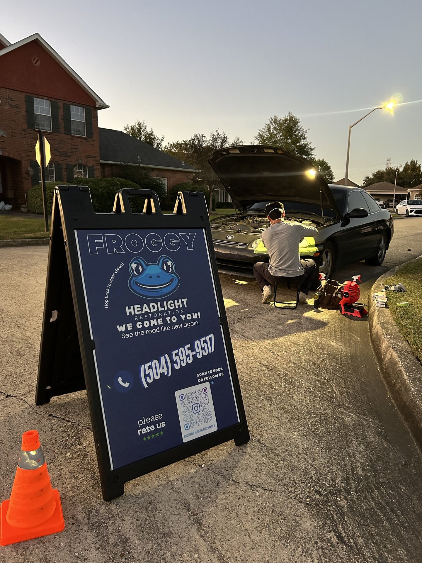 froggy headlight restoration advertising sign and working on a clients vehicle