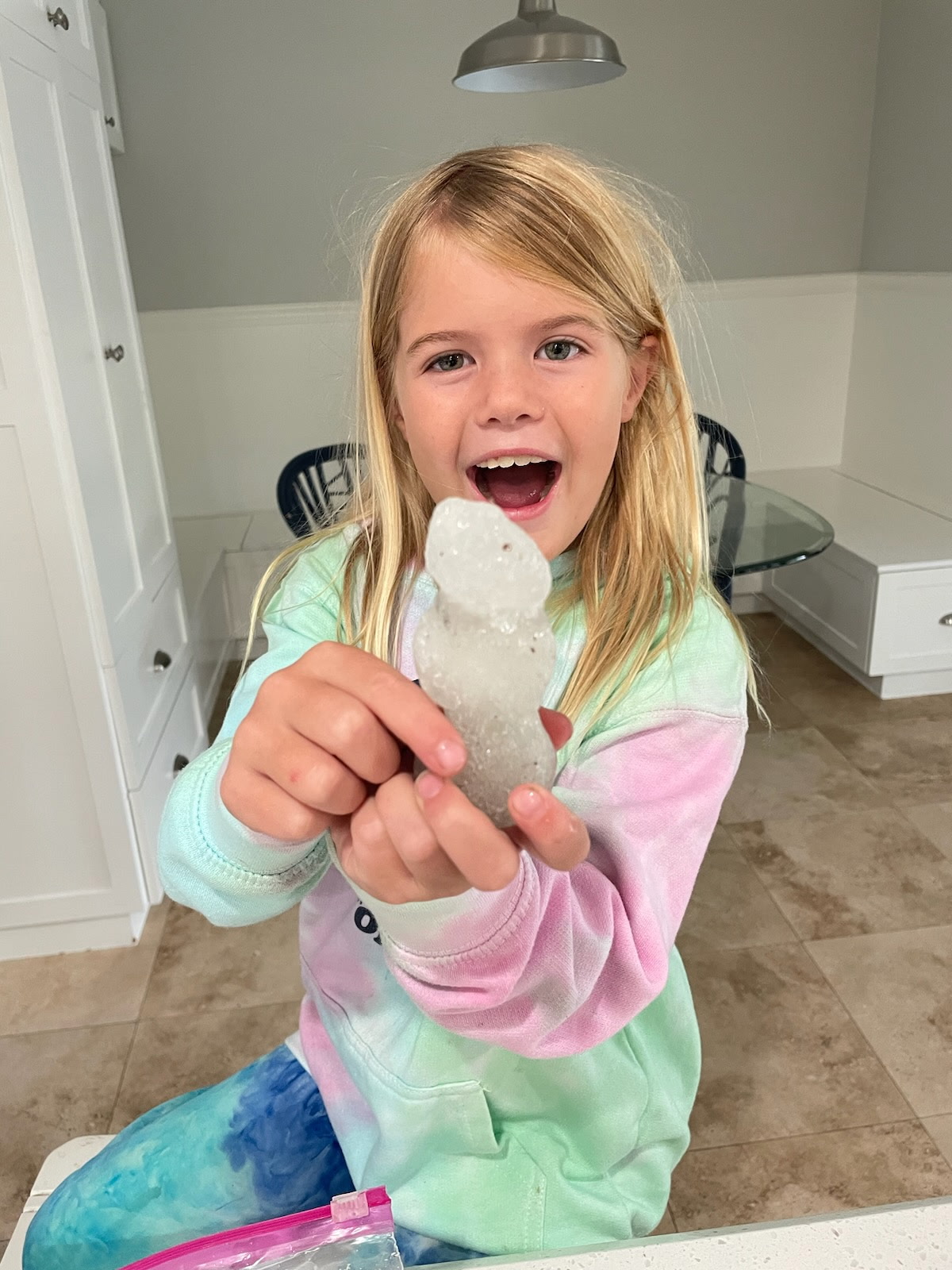Mary Grace holding a snowman with a big smile on her face