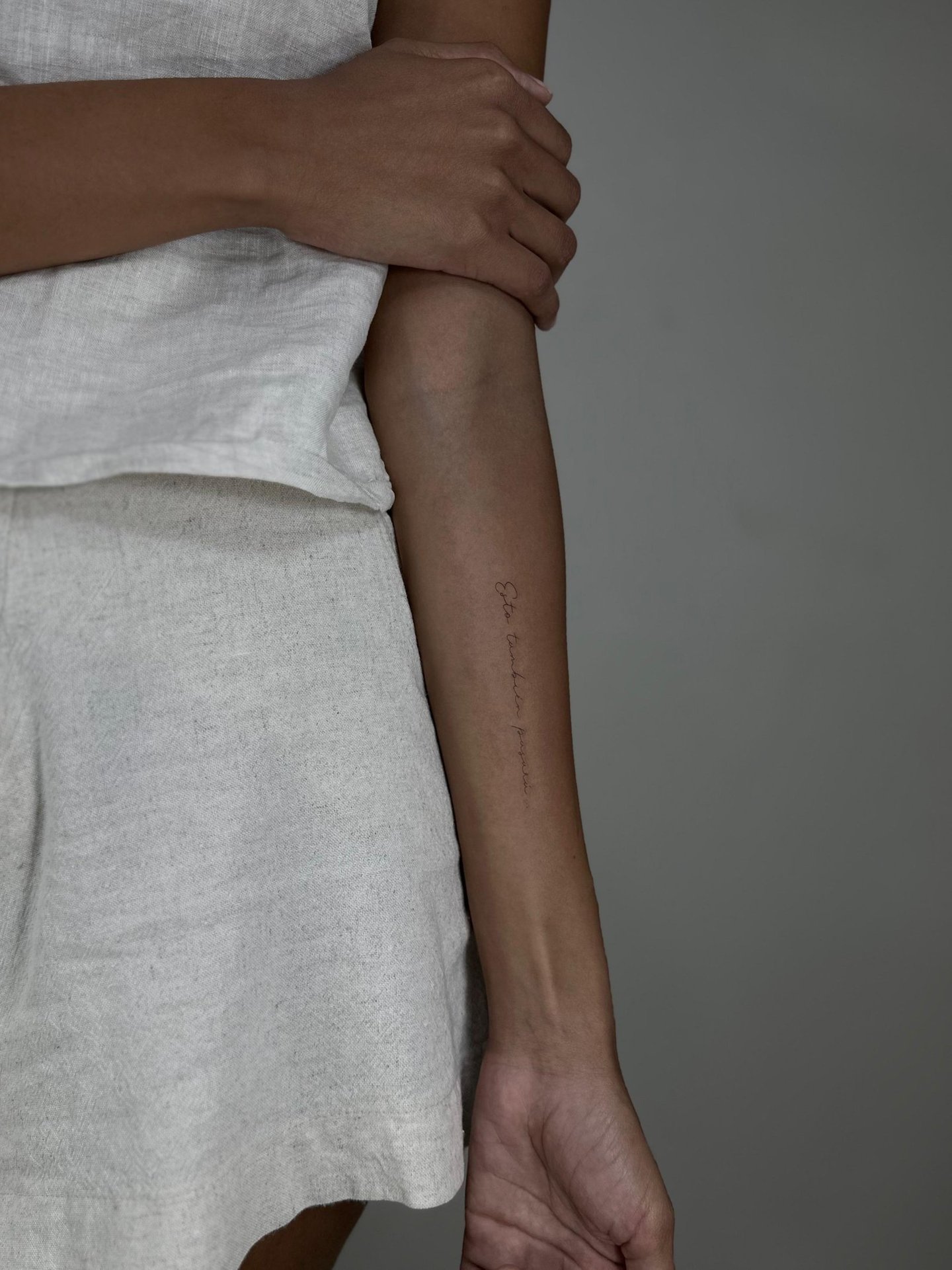 Tatuaje fineline en Madrid de frase manuscrita vertical en escritura cursiva muy fina 