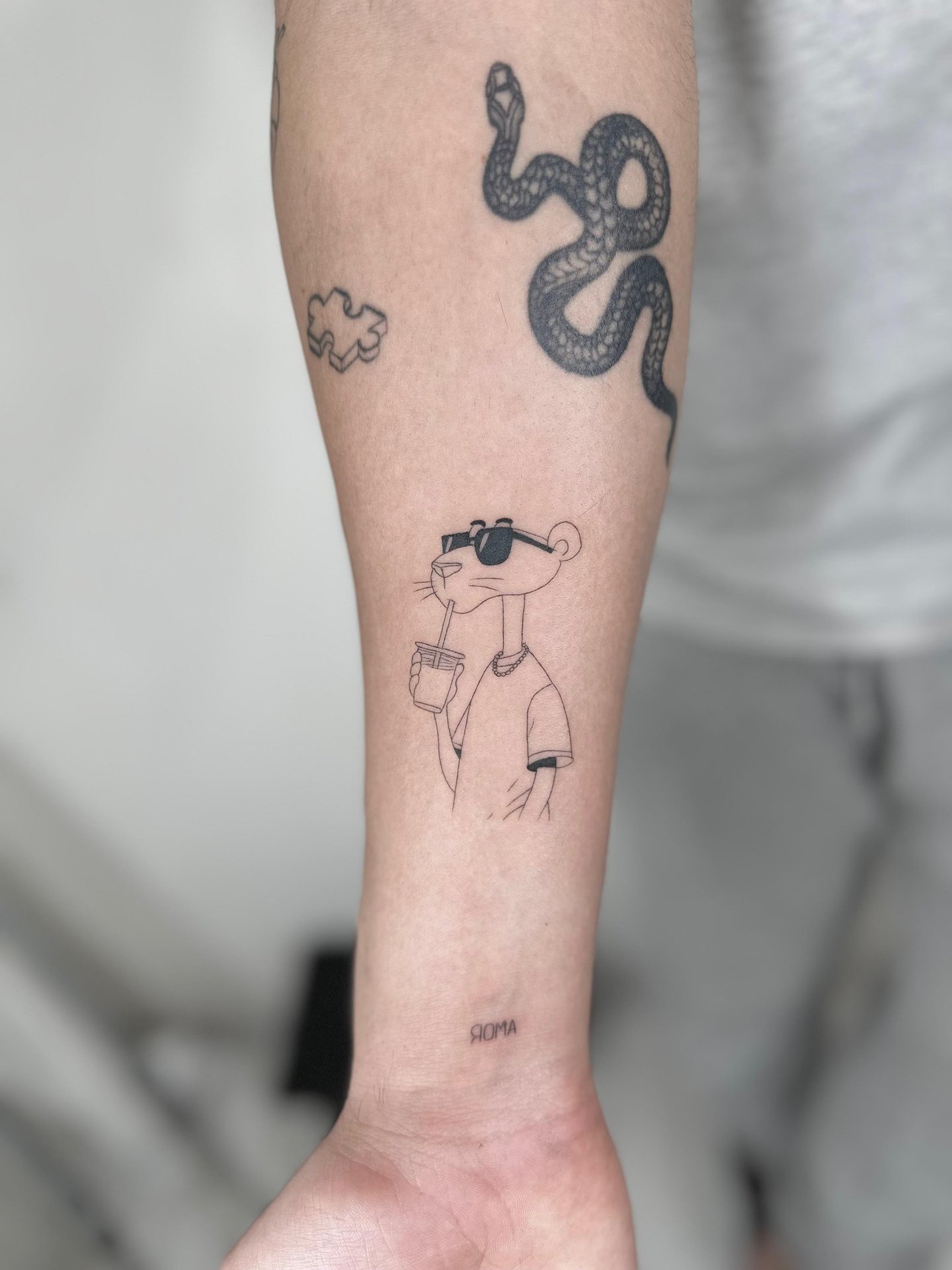 Tatuaje fineline en Madrid de la Pantera Rosa con gafas de sol y batido