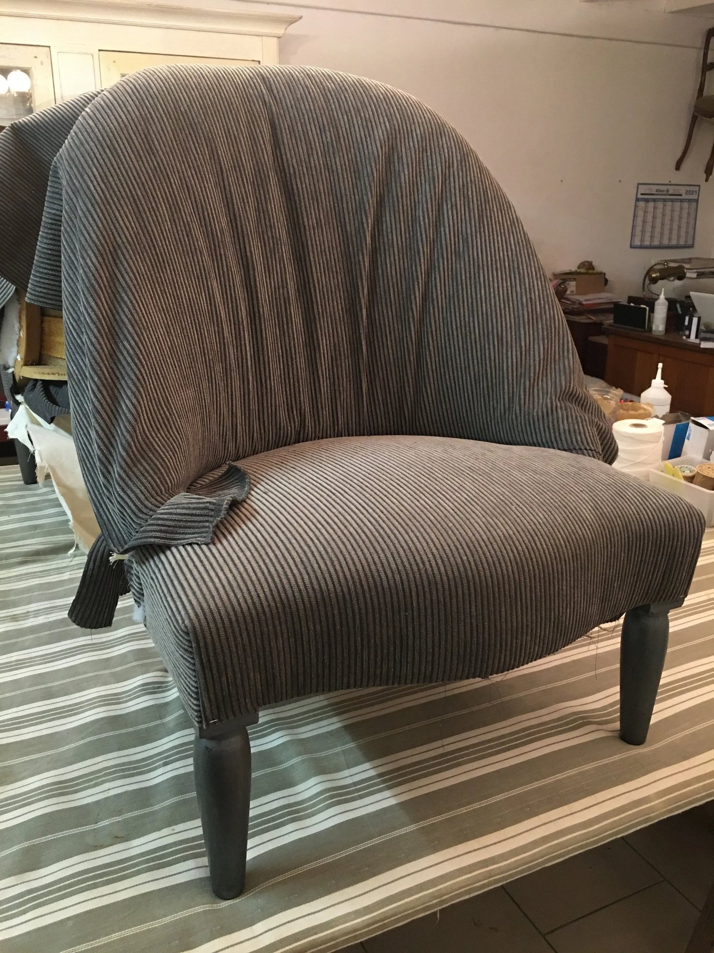 Chauffeuse recouverte d'un tissu en train d'être posé