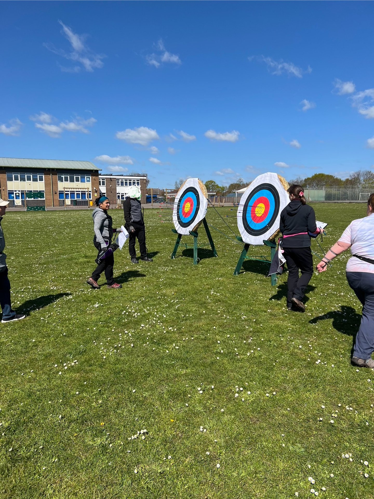 a group of people walking up to an archery target