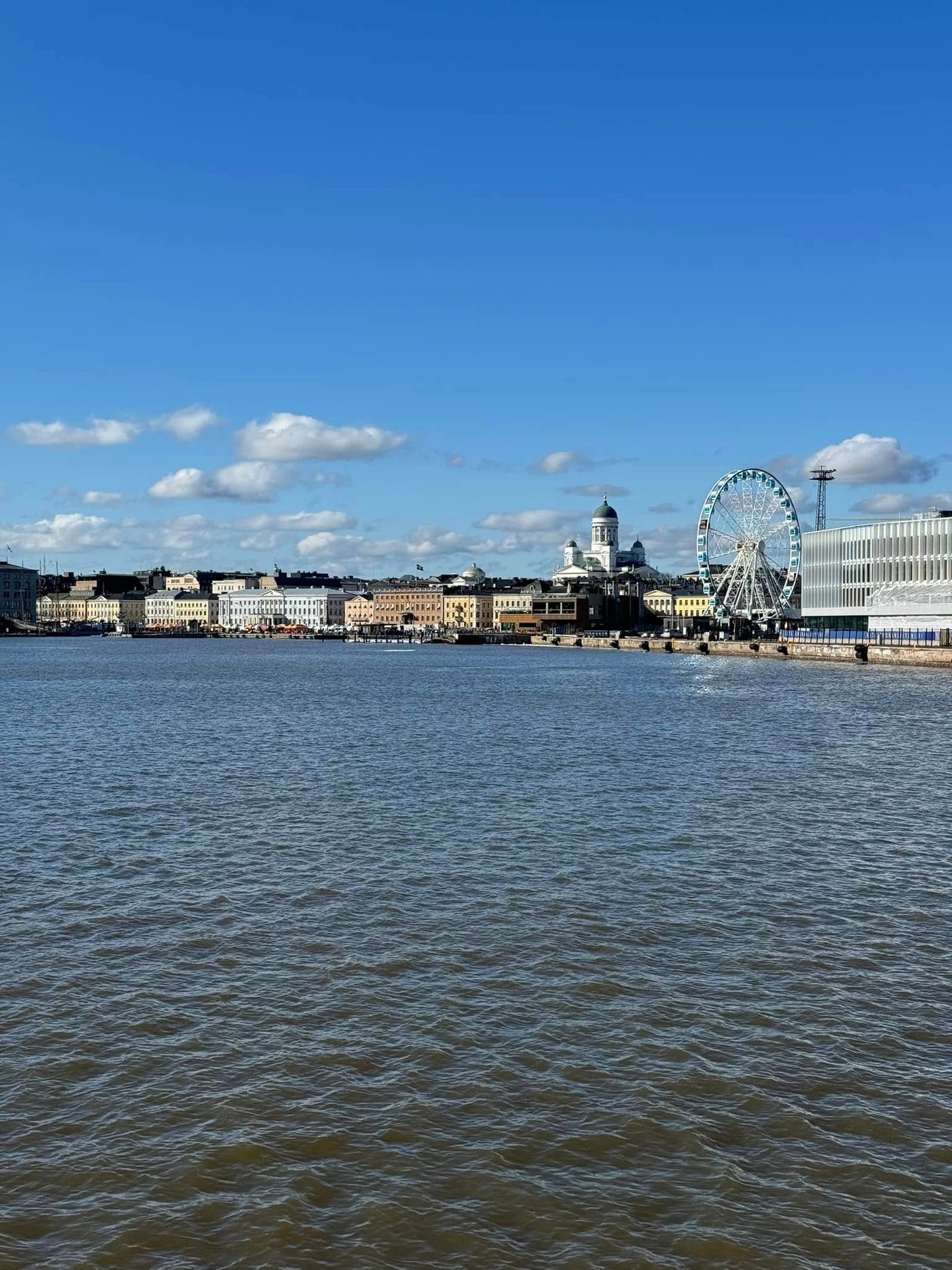 a view of the harbor with a ferris wheel and cathedral in the background
