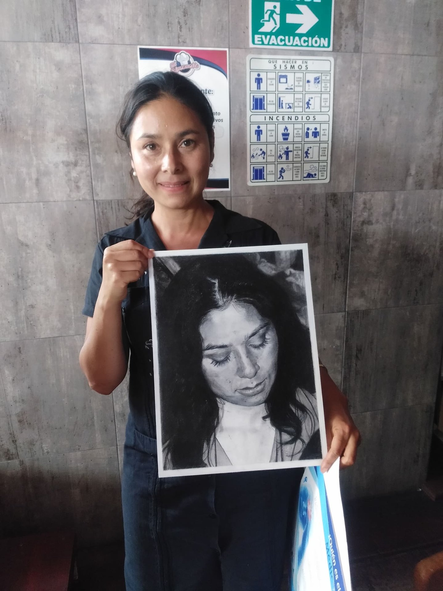 Mujer sosteniendo retrato realista a grafito y carboncillo de mujer con ojos cerrados, obra de arte