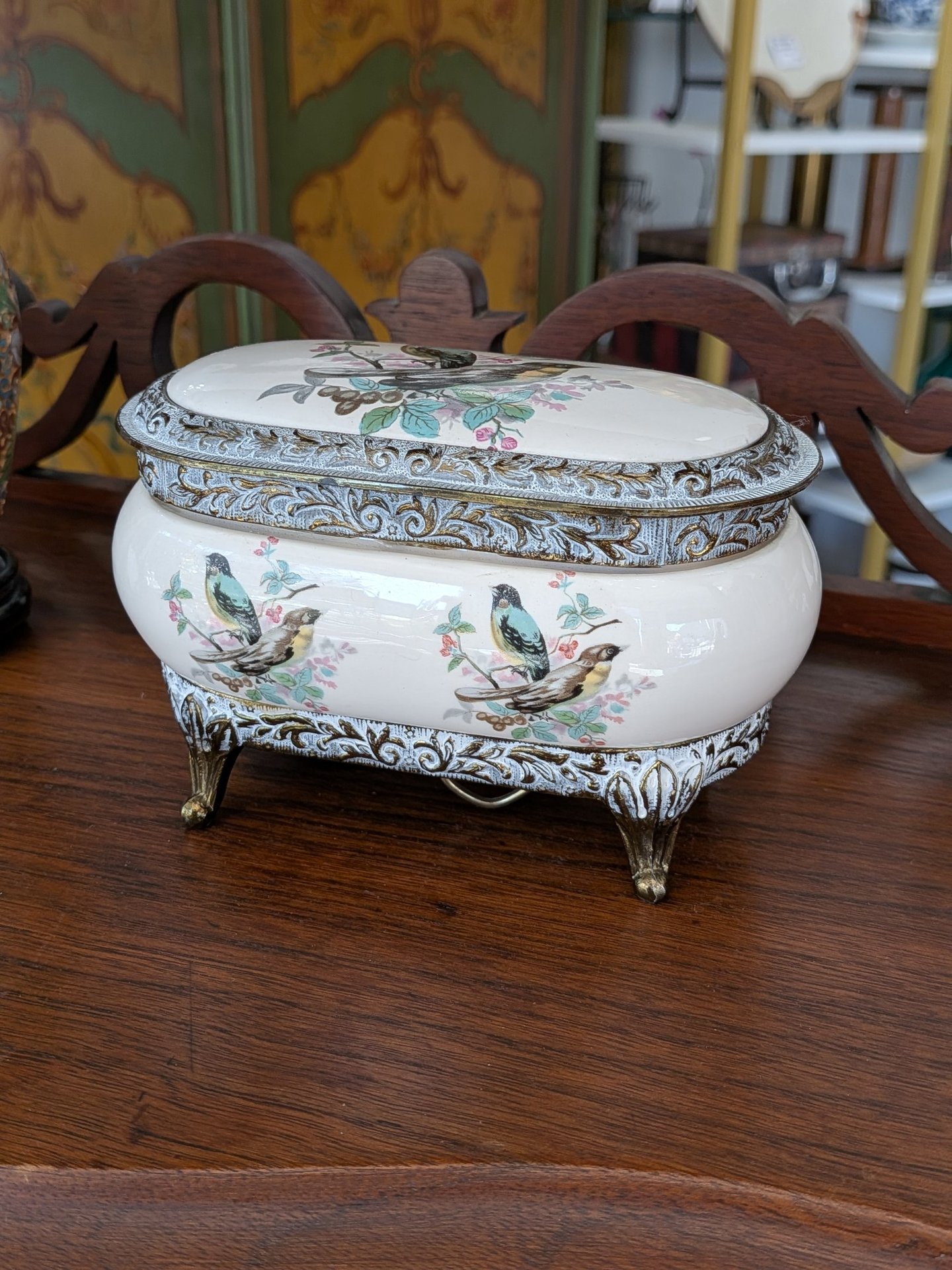 Vintage ceramic jewelry box with floral bird illustrations and ornate gold filigree trim.