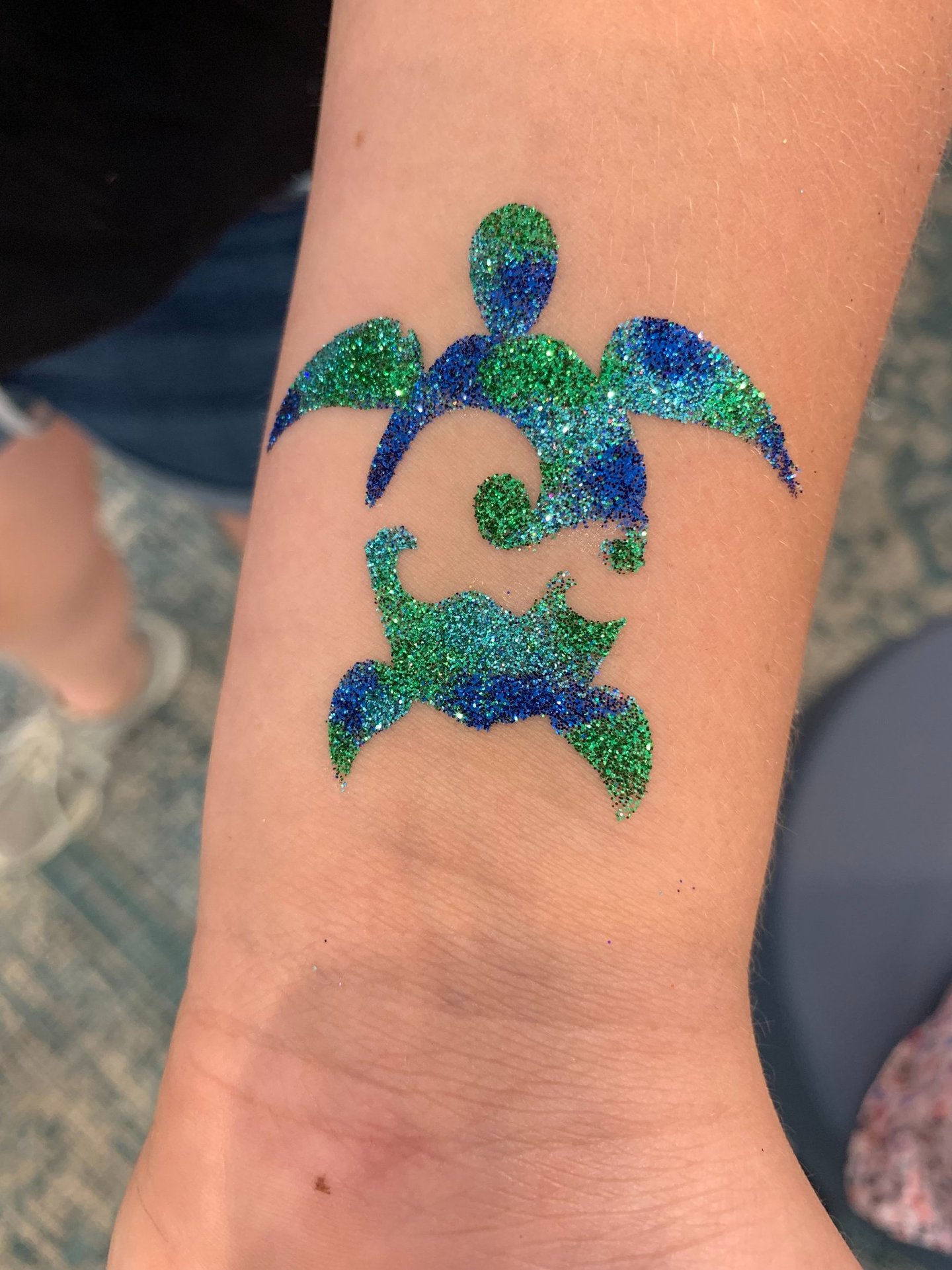 sea turtle glitter tattoo on skin with glitter colors of blue, aqua, and green