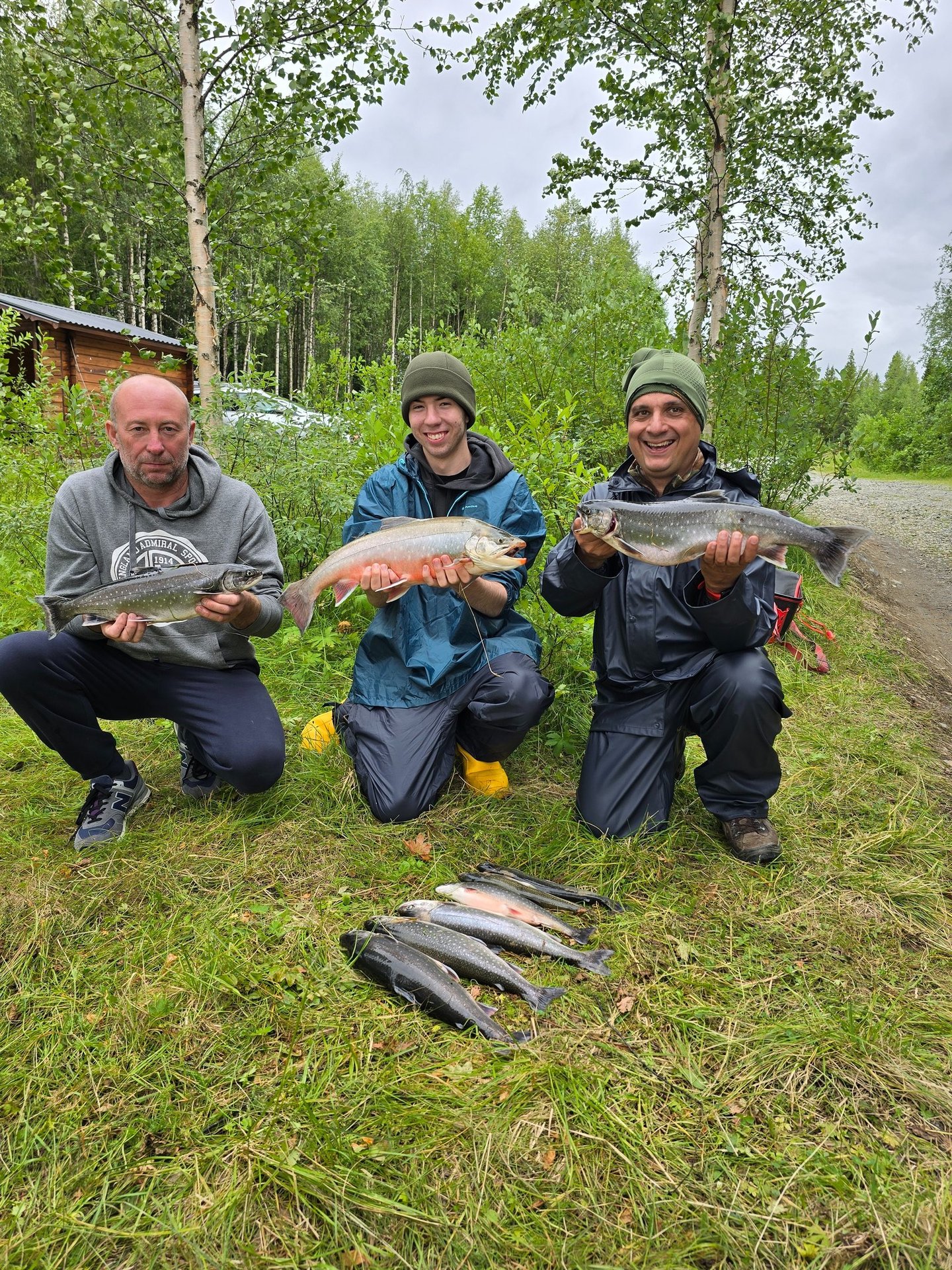 a group of people holding fish on a field