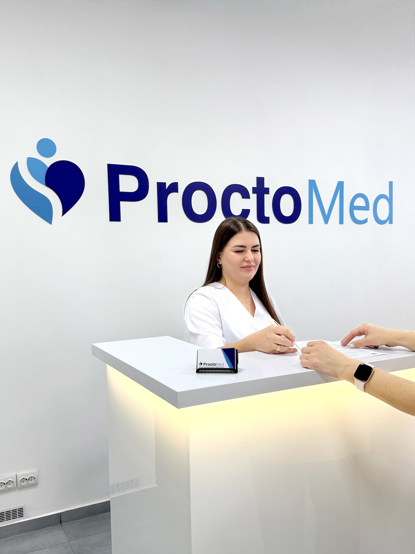 Receptionist at ProctoMed medical center in Rivne assisting a patient.