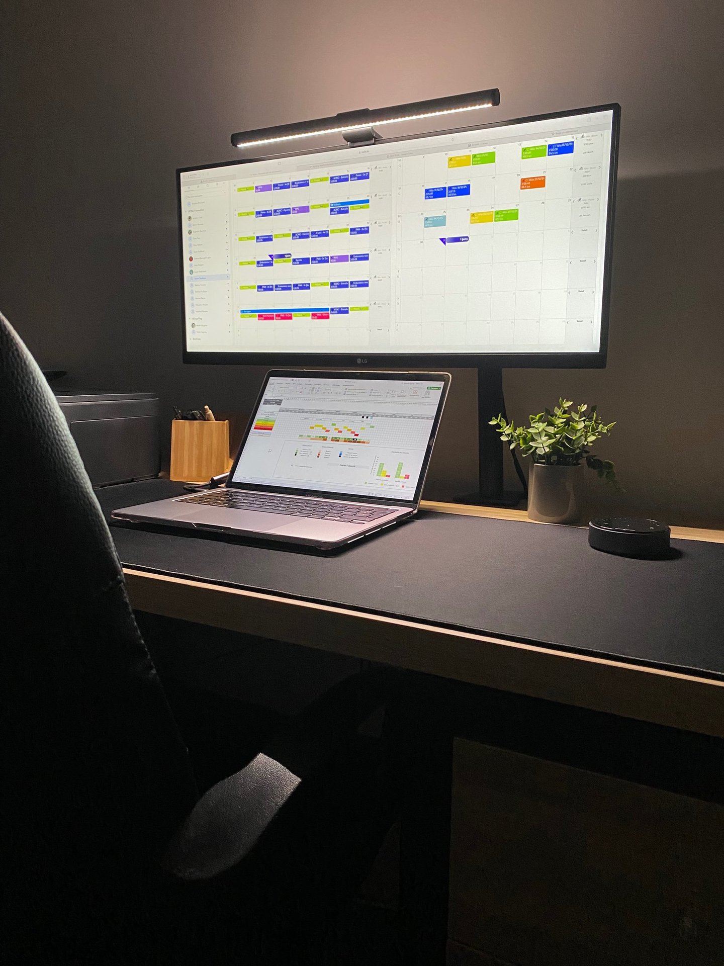 Modern minimalist home office setup with ultrawide monitor, laptop, and LED desk screen bar.