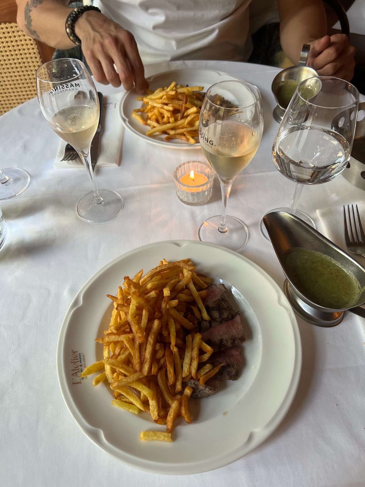 Champagne and golden fries served at a sunlit French brasserie table, capturing an effortless luxury moment.