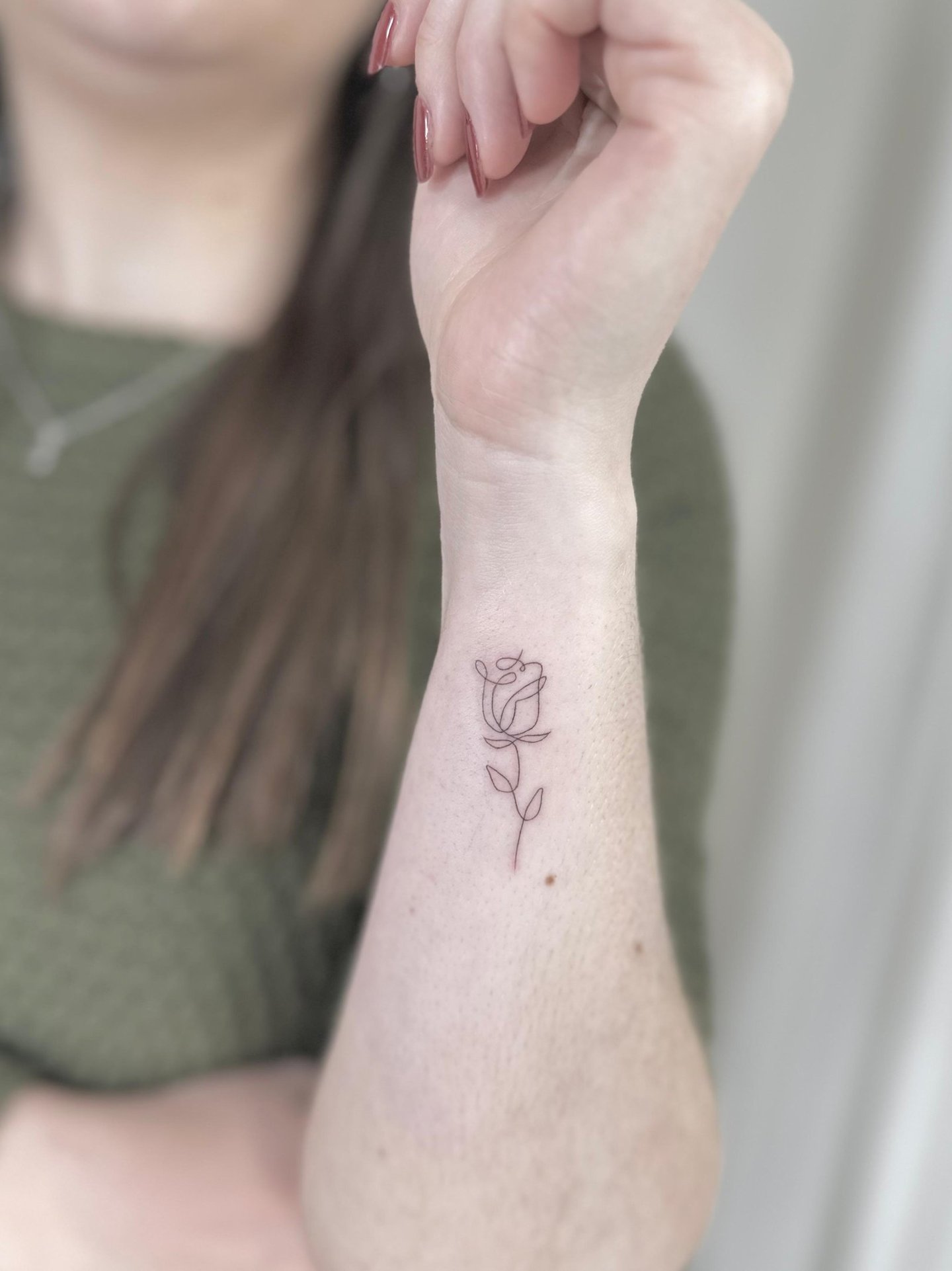 Tatuaje fineline en Madrid de rosa minimalista dibujada con trazo único y continuo