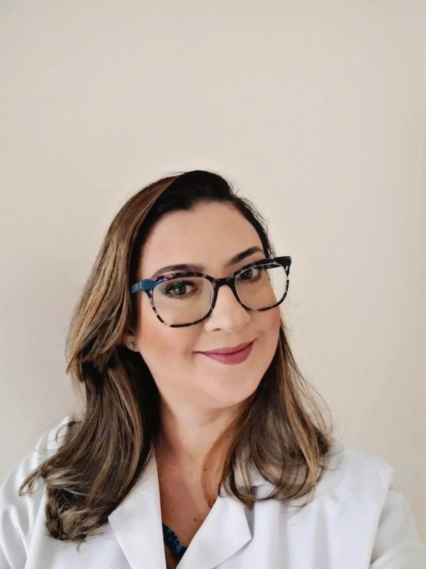 Retrato de uma mulher em estilo selfie, da cabeça ao busto, em formato retrato três por quatro.