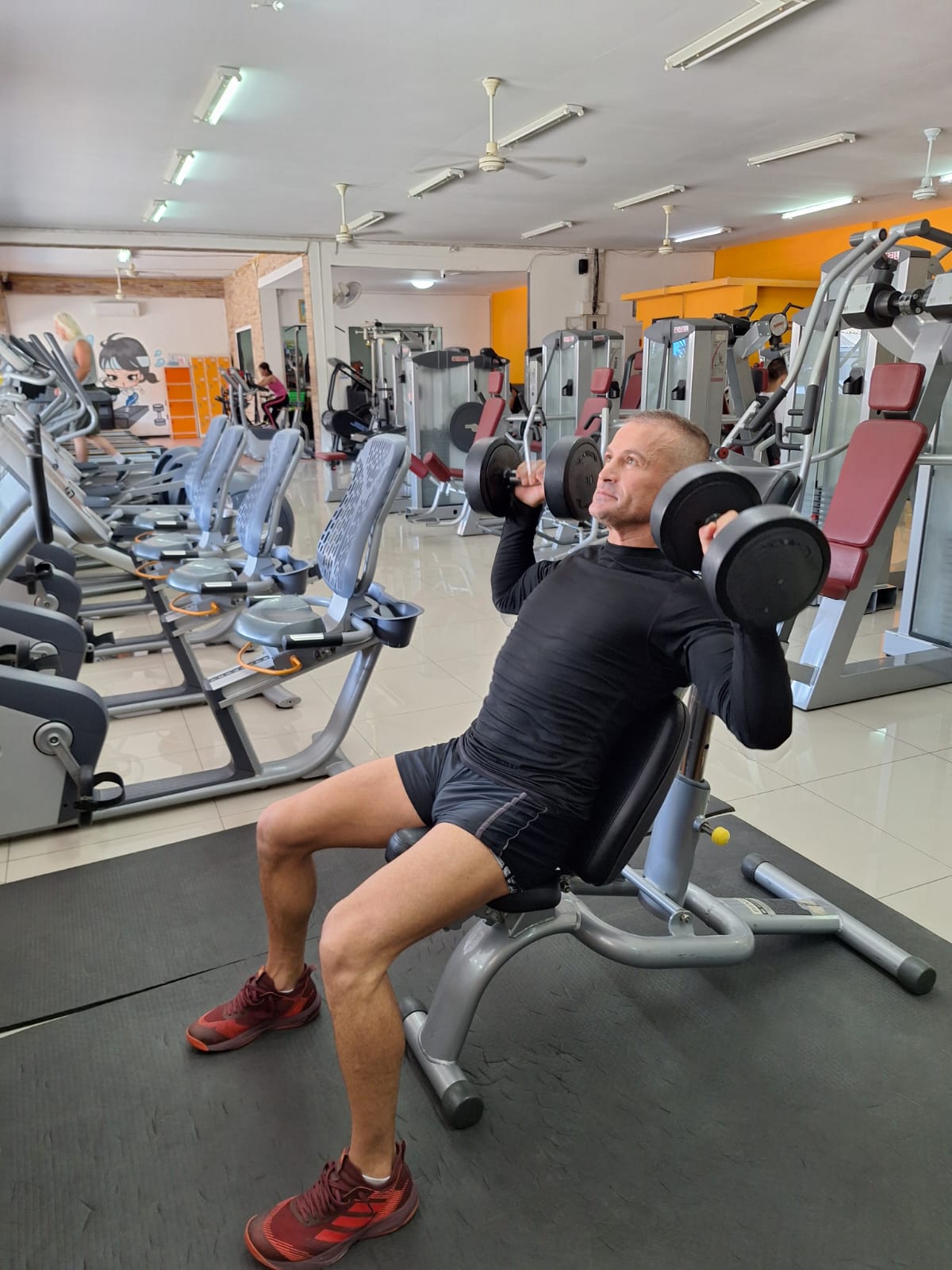 Male therapist lifting dumbells in a gym in Pattaya