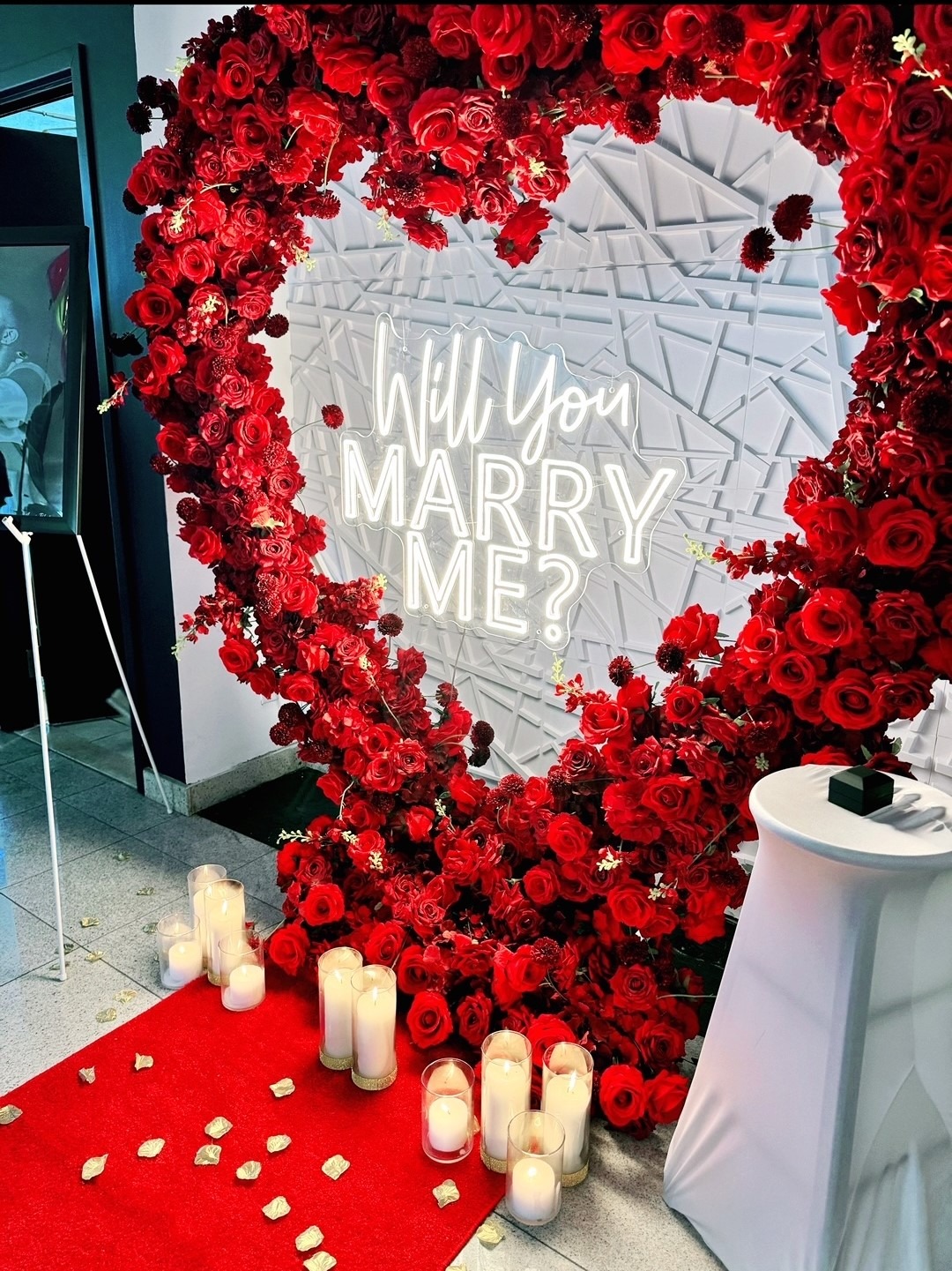 A heart-shaped arrangement of silk roses in shades of red,