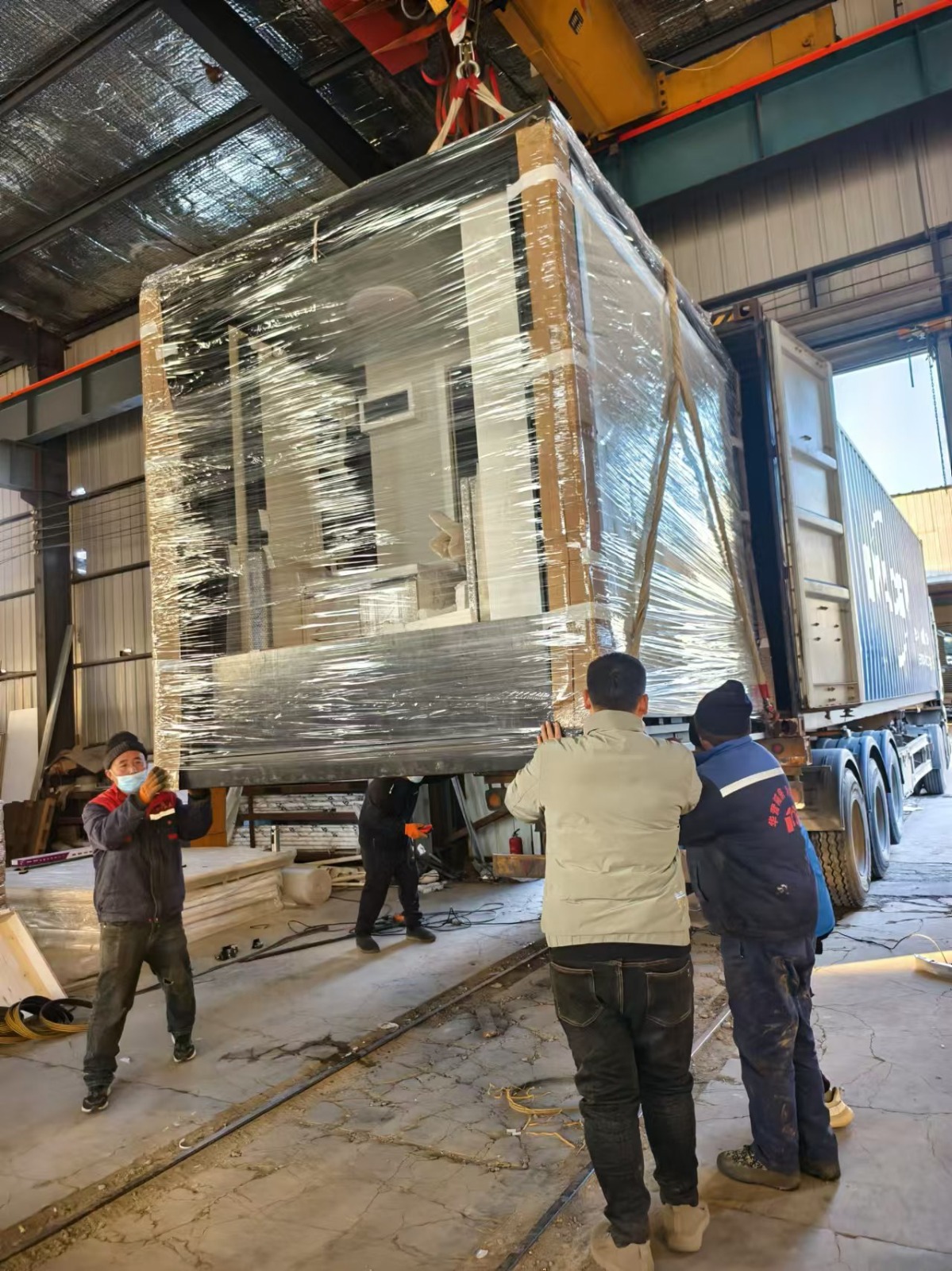 Chargement d'une maison préfabriquée déployable dans un camion.