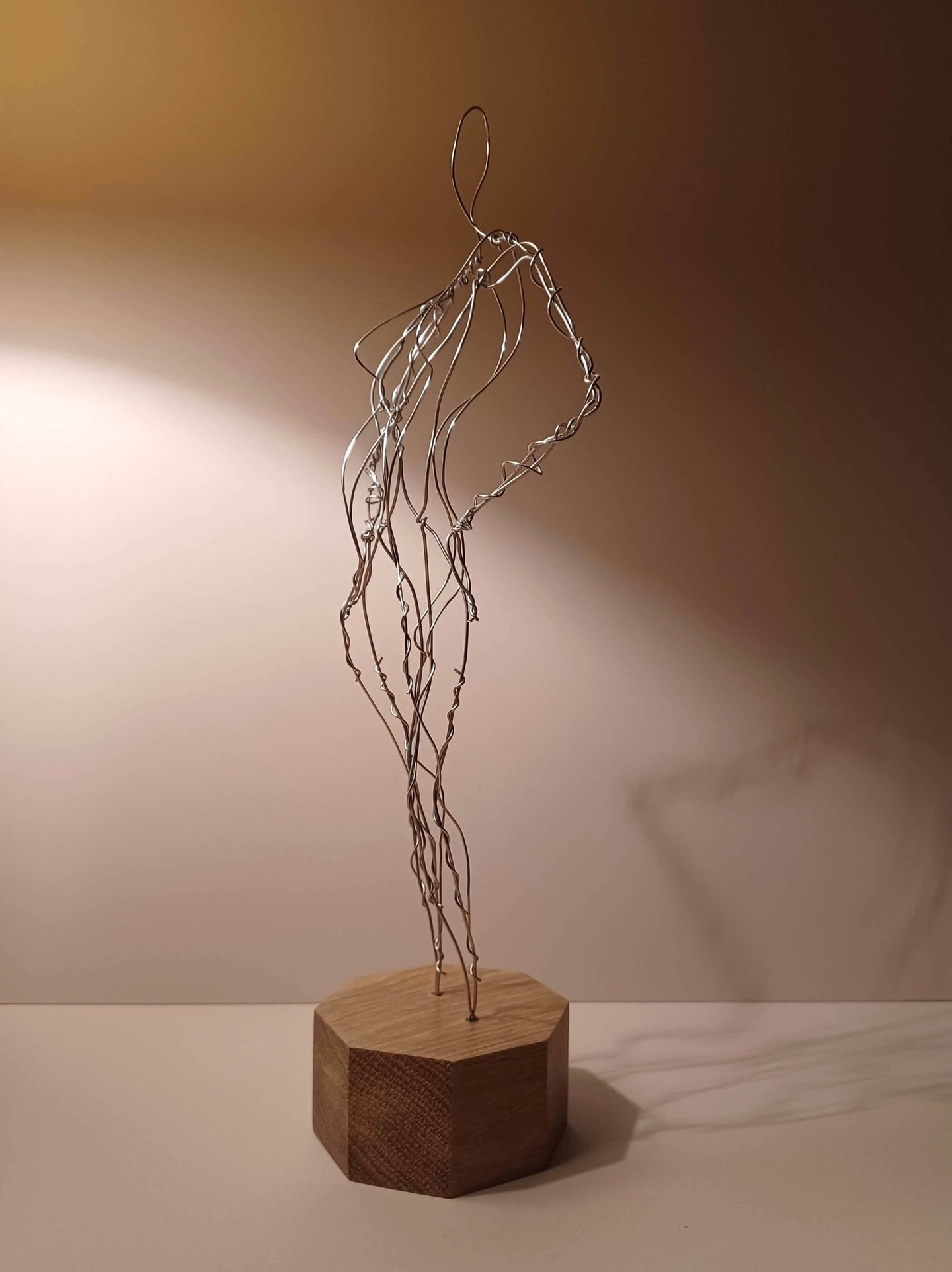 A wire sculpture of a complete female figure, standing with hands on hips