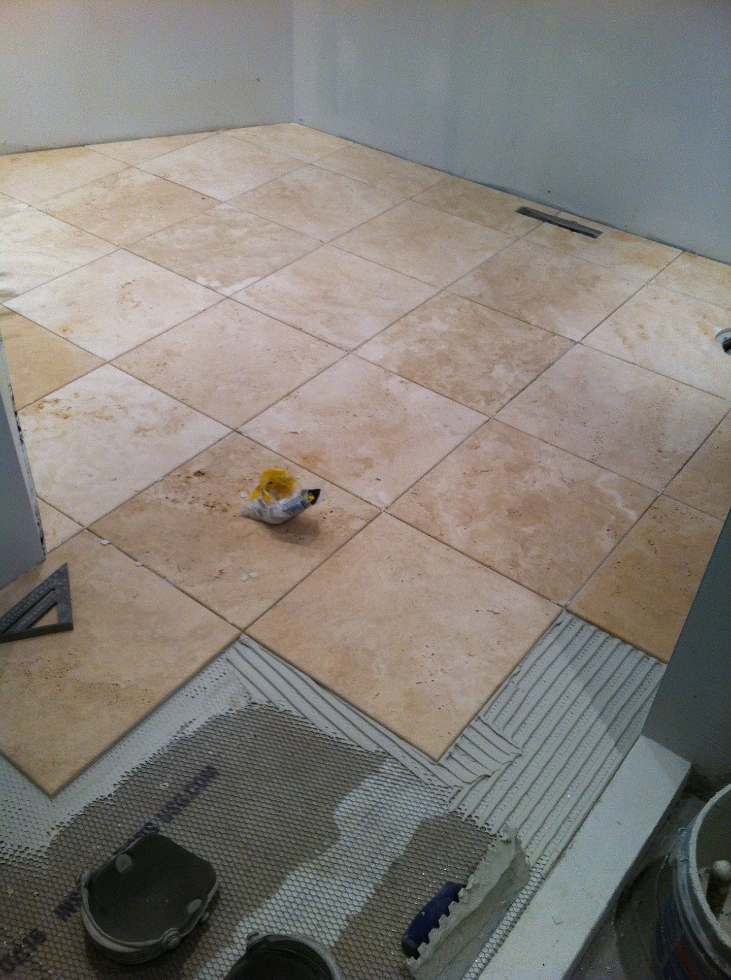 Close-up of a craftsman carefully laying marble tiles on a floor.